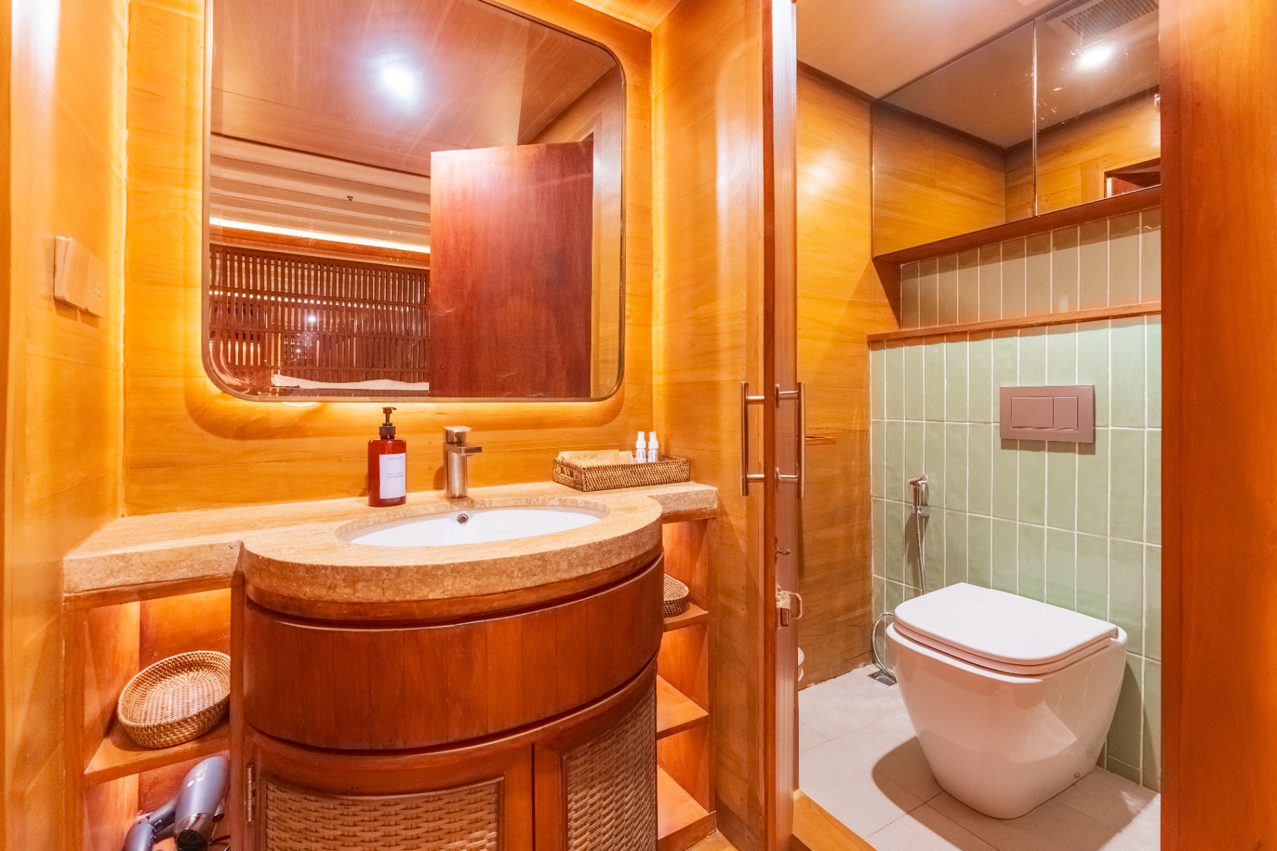 Lower-deck cabin ensuite on Sanctuary with travertine vanity, backlit mirror and separate toilet