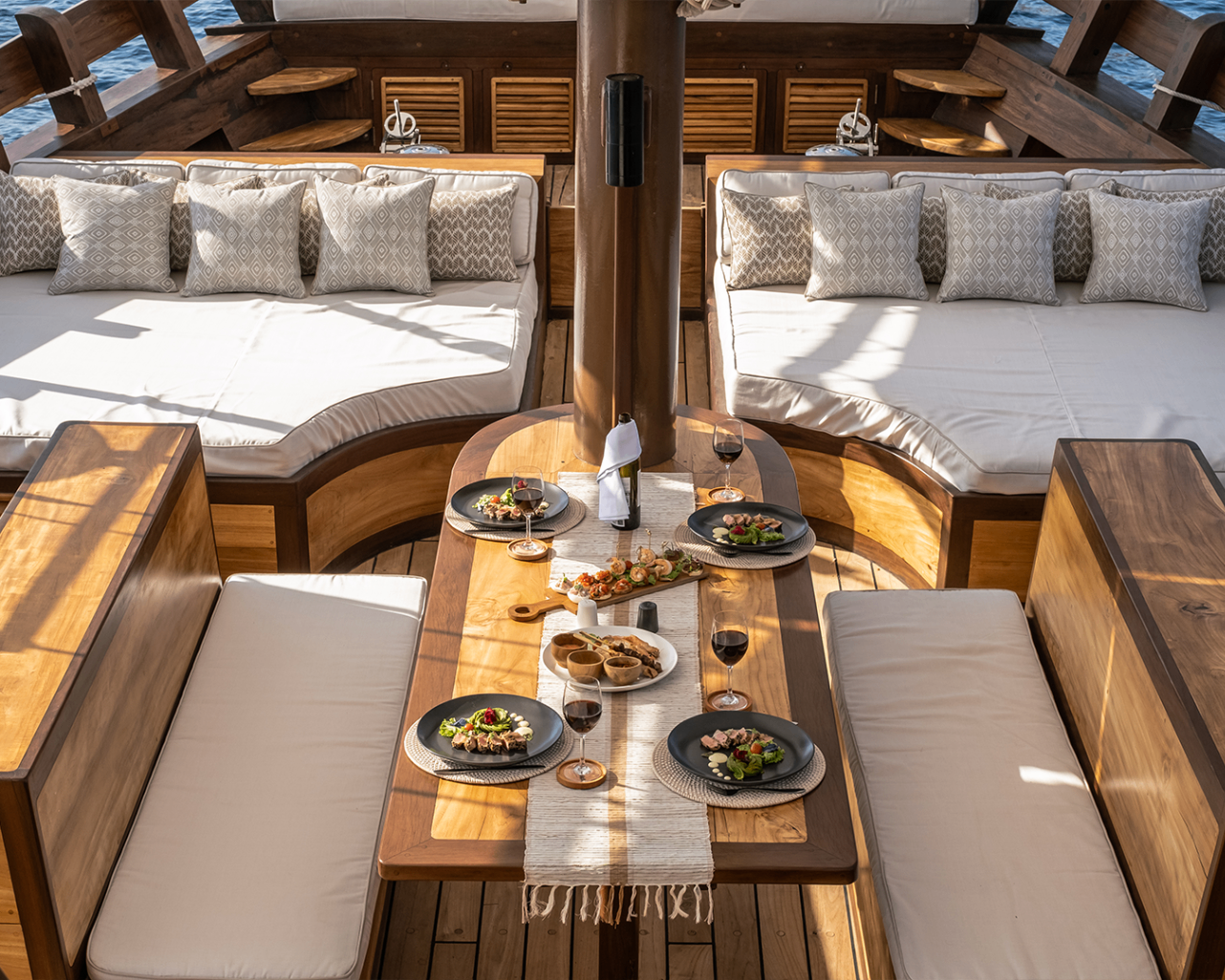 Overhead view of Sanya's communal dining table framed by curved daybeds and wine service