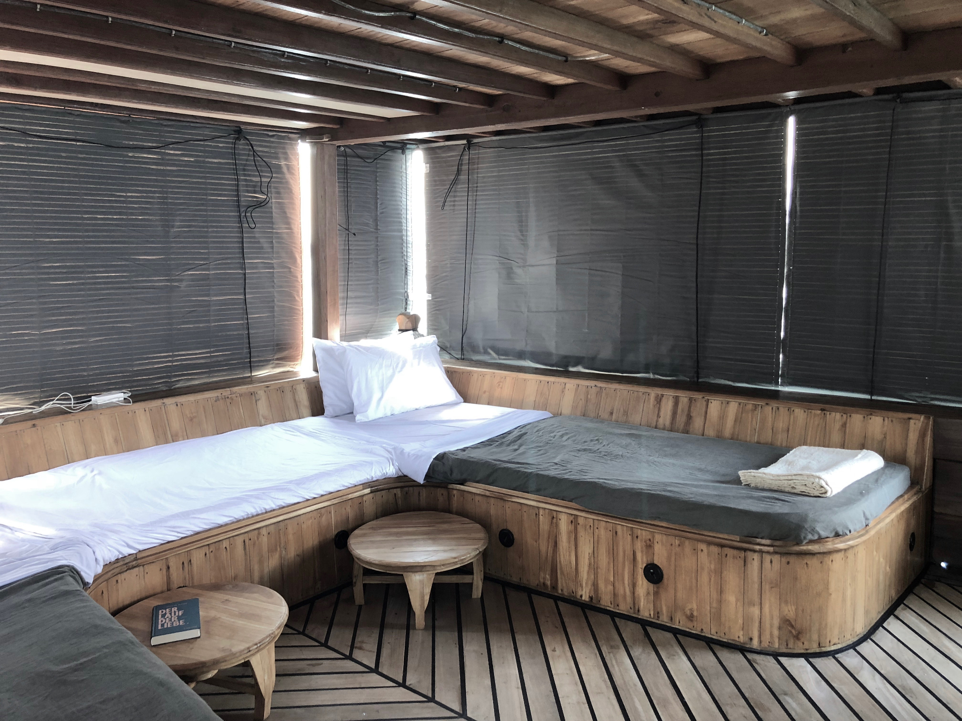 Splendour open-air deck cabin with twin daybeds, timber panelling and shade blinds