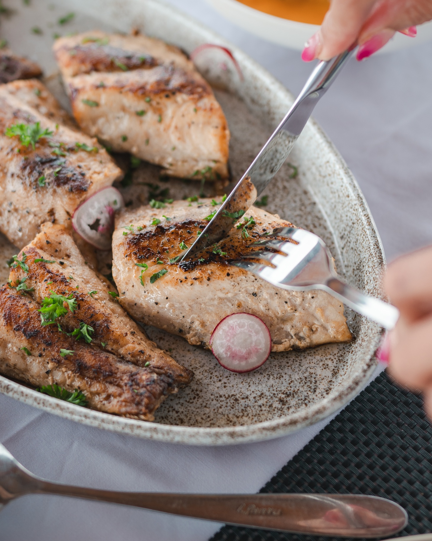 Pan-seared reef fish fillets with parsley and radish on a speckled ceramic platter aboard Mischief