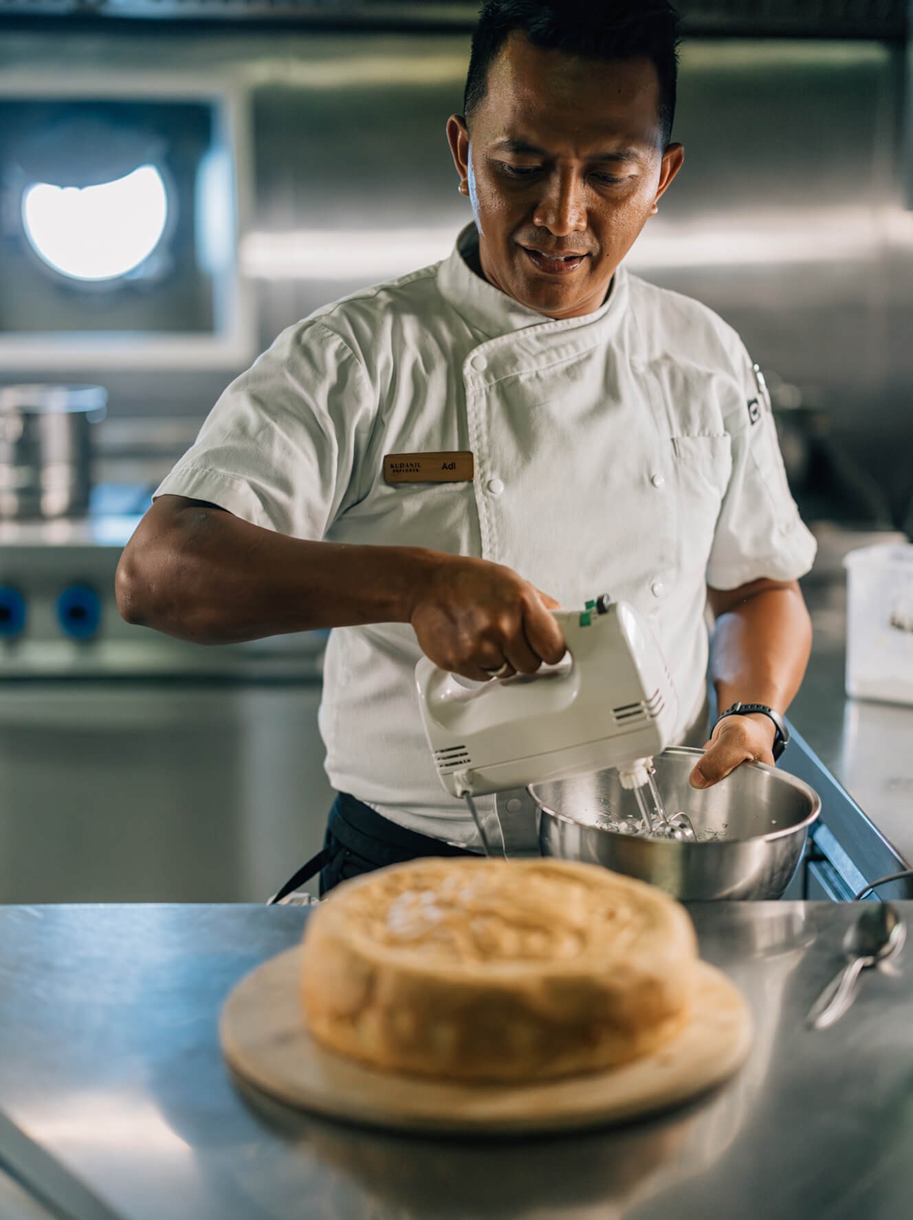 Chef Adi preparing a fresh cake in Kudanil Explorer's galley