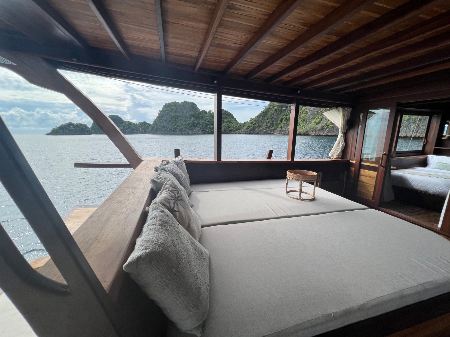 Dewata aft chill deck daybed facing karst islands across calm water
