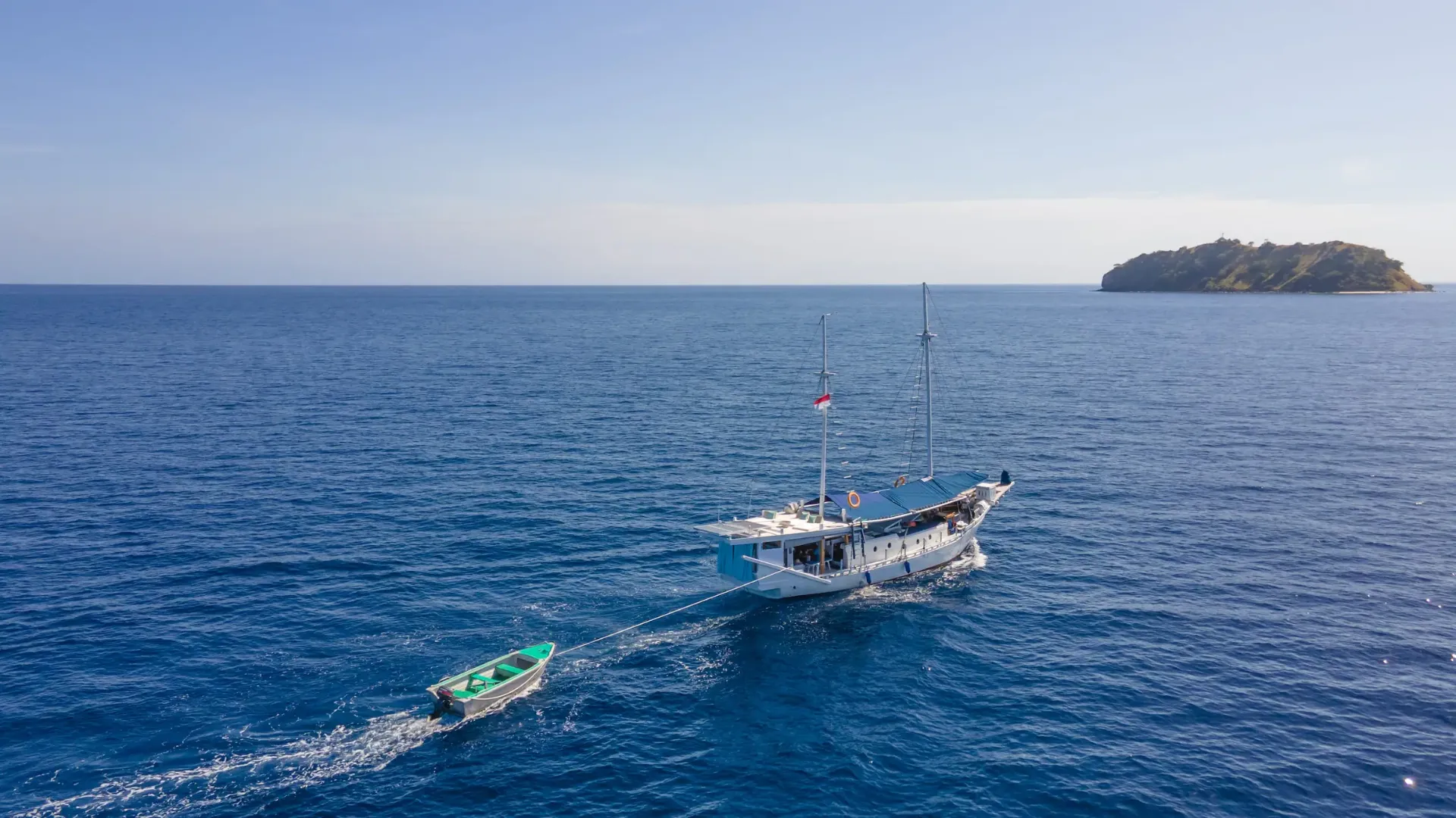 Aerial of Jinggo Janggo underway with tender in tow on deep blue water