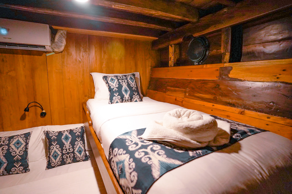 Single bed cabin on Adishree with porthole, reading light and ikat cushions