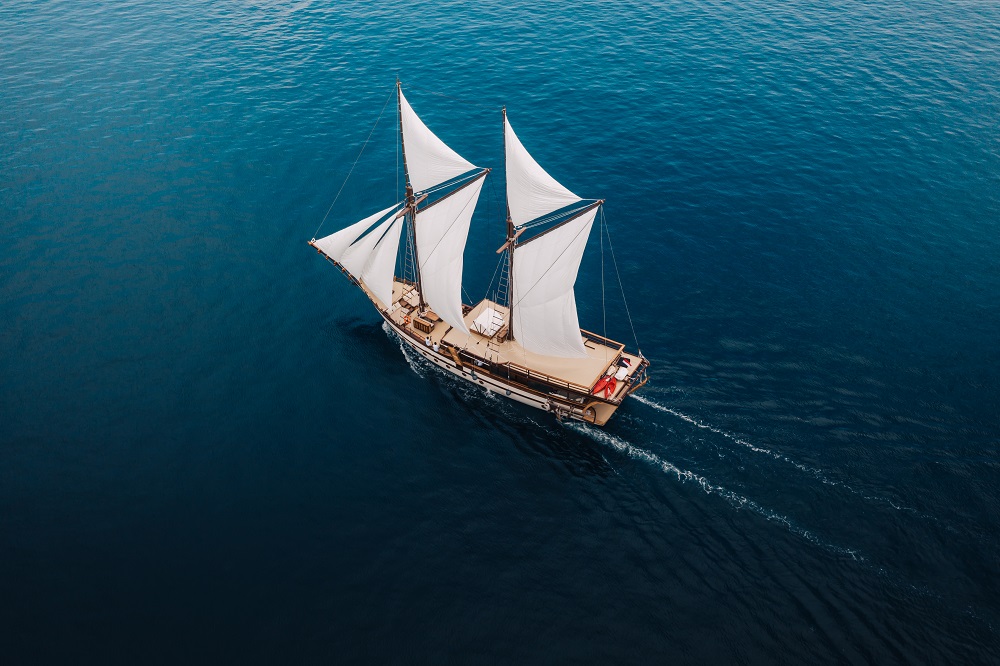Aerial of Senja sailing on deep blue water with a clean wake behind