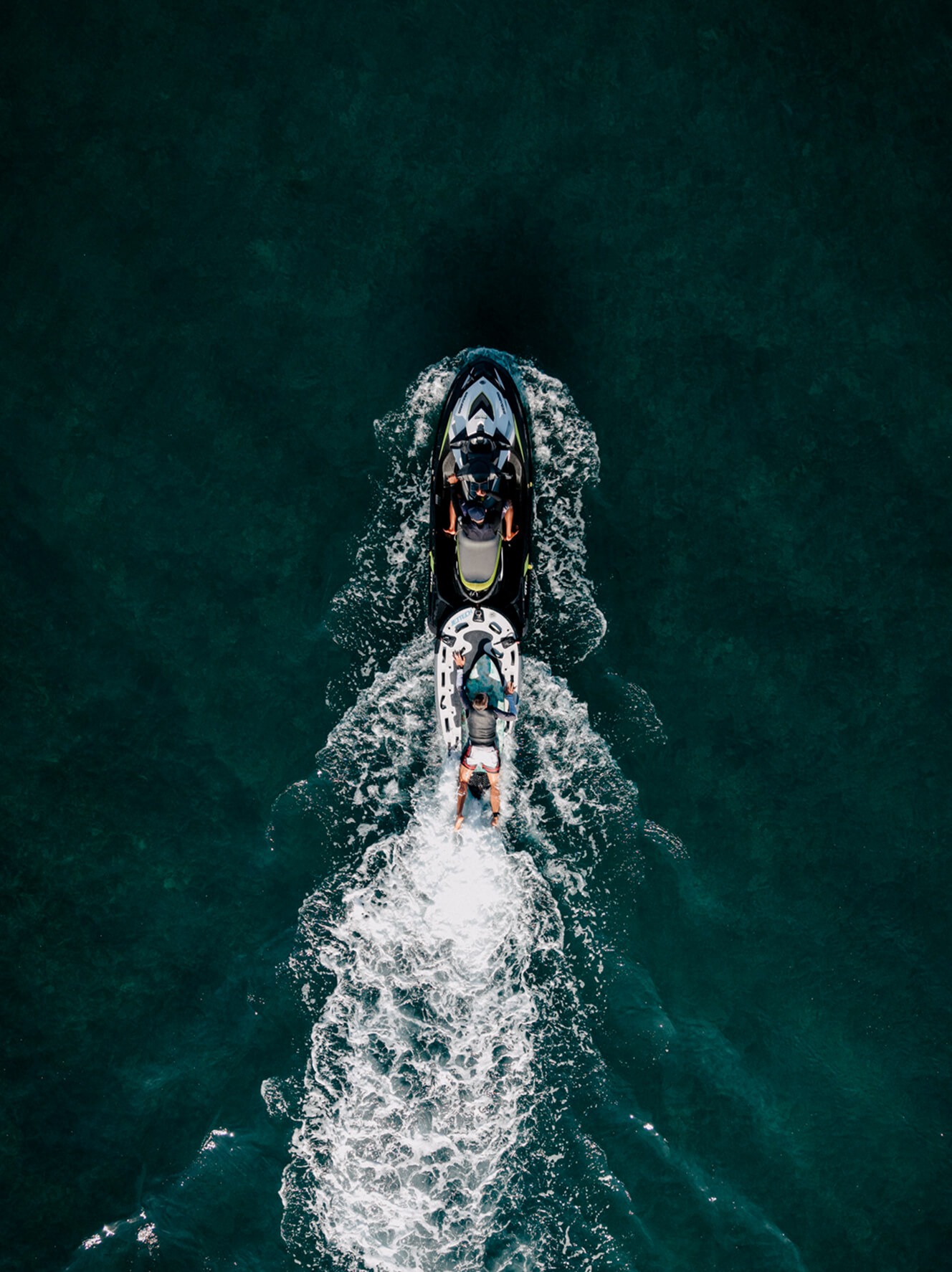 Aerial view of a jet-ski towing a rider on a Jetsurf board