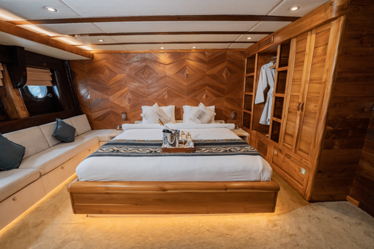 Swordfish guest cabin on Lamima with king bed, geometric teak headboard wall and ensuite wardrobe