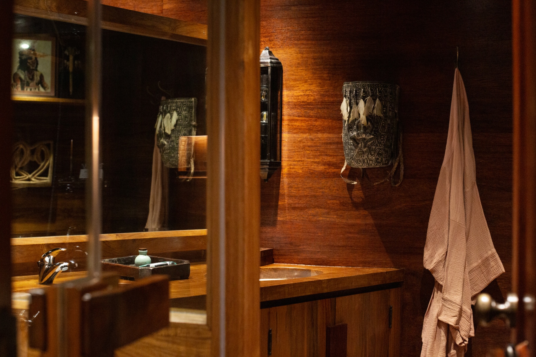 Ensuite bathroom on Silolona clad in warm timber with antique tribal artefacts