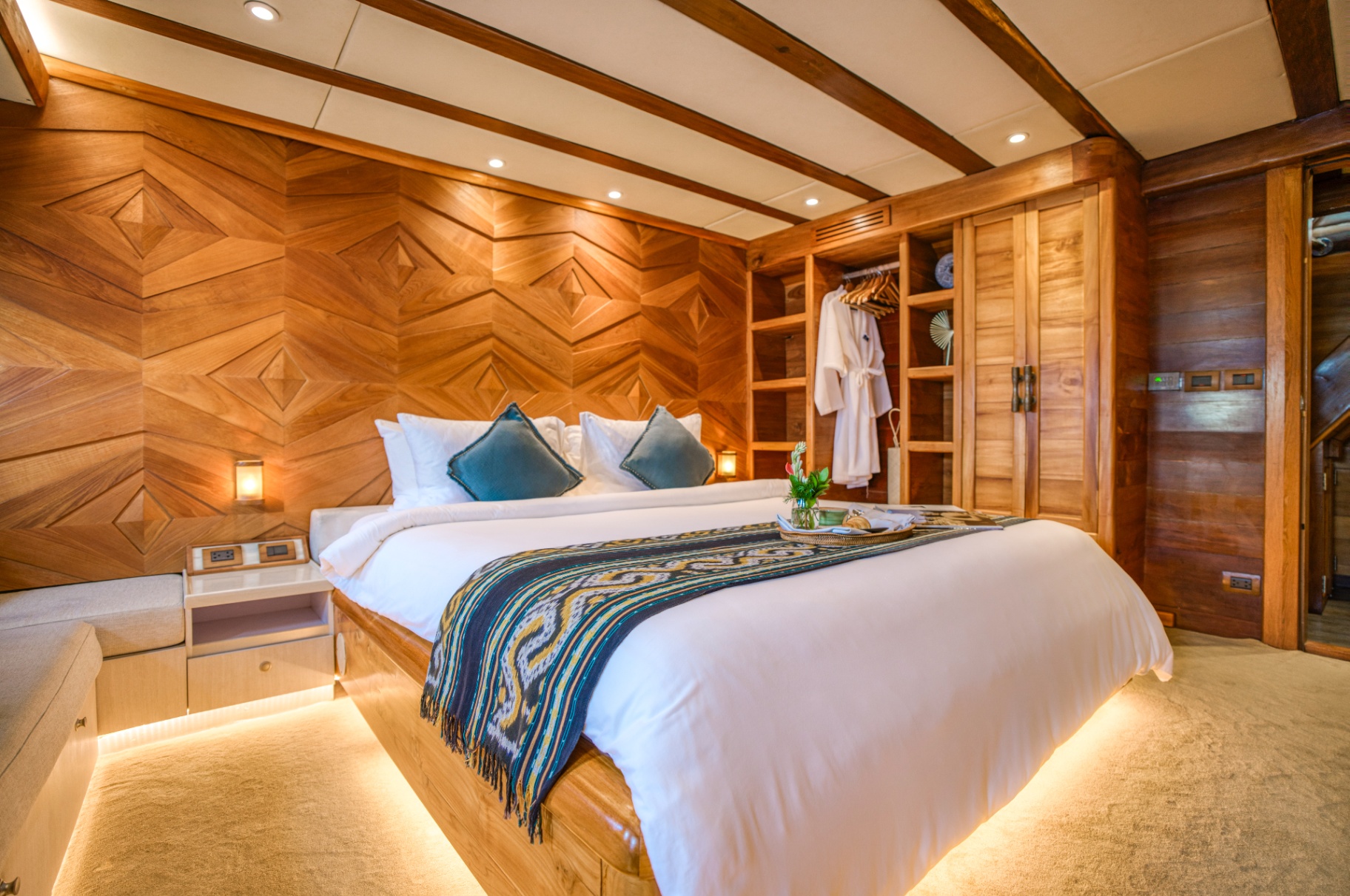 Guest cabin on Lamima with king bed, ikat runner and teal accent cushions
