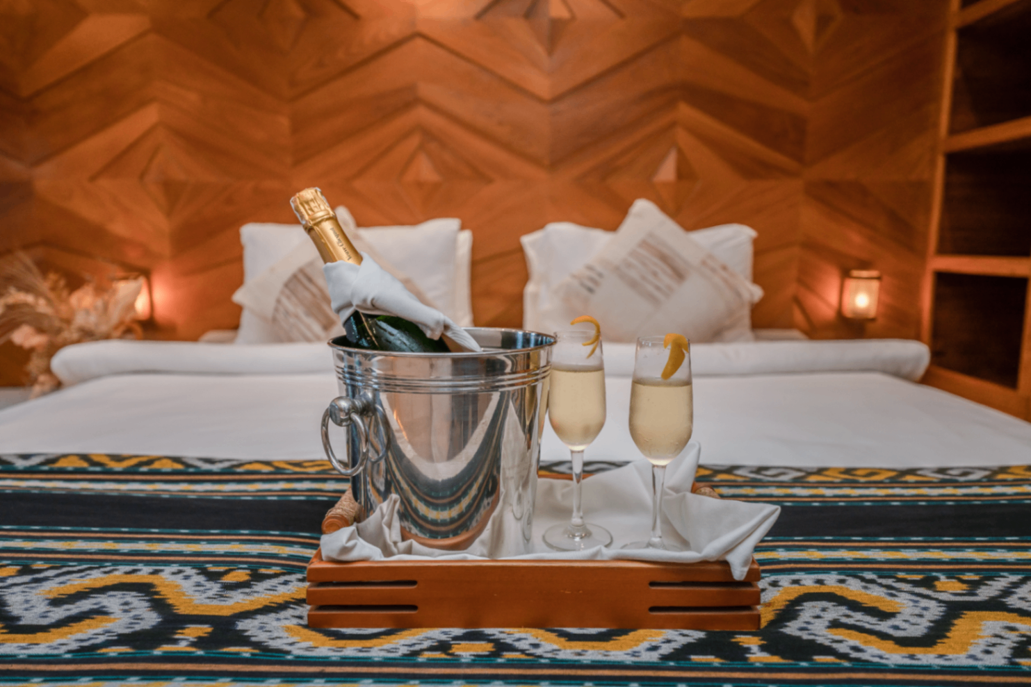 Chilled champagne on ice with two flutes set on a woven ikat runner in the Swordfish cabin