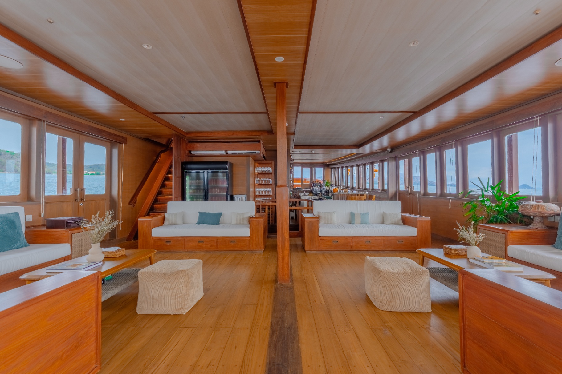Wide indoor lounge on Sanctuary with facing sofas, coffee tables and panoramic sea-view windows