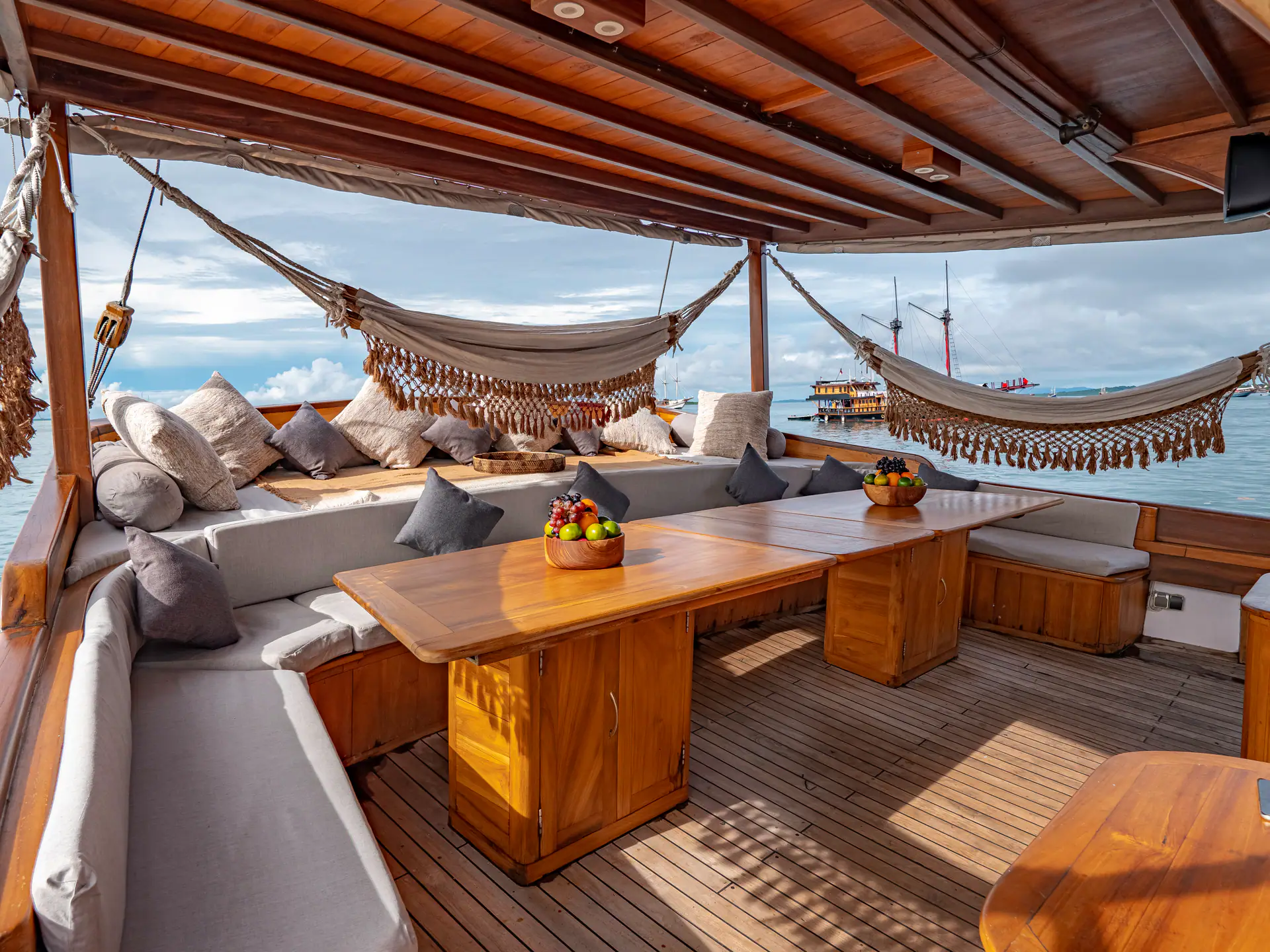 Anne Bonny aft deck with hammocks, sofas and dining table over the water