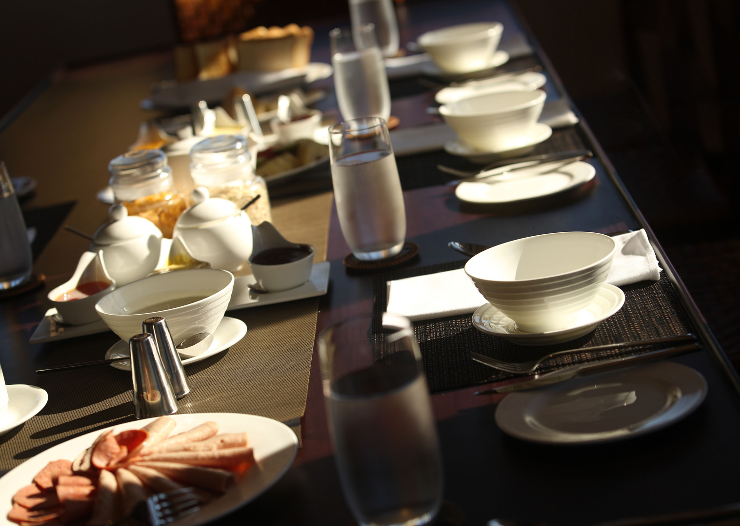 Breakfast service on Alila Purnama with fresh fruit, pastries and warm morning light