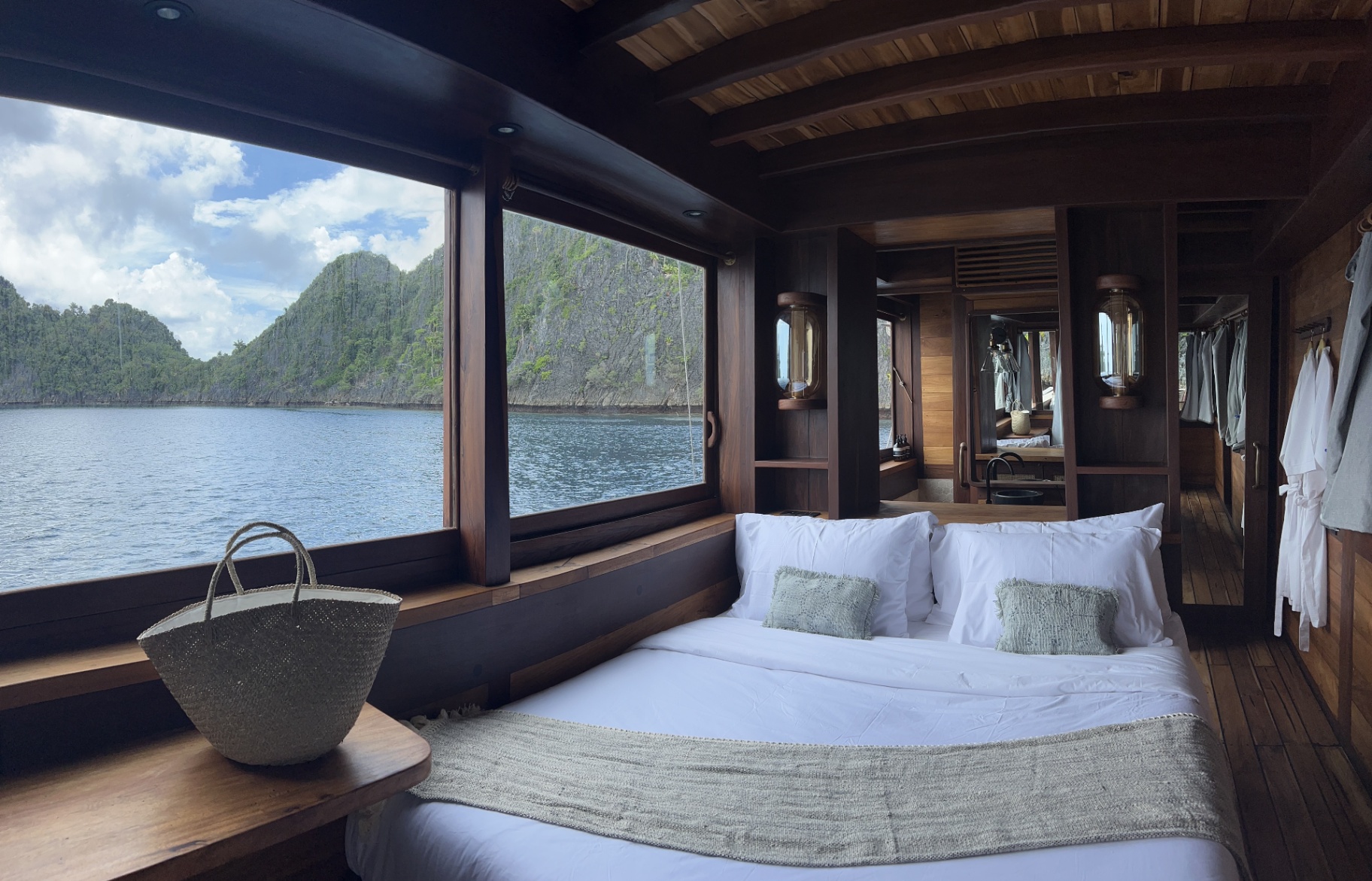 Dewata master cabin with panoramic window framing Raja Ampat karst islands