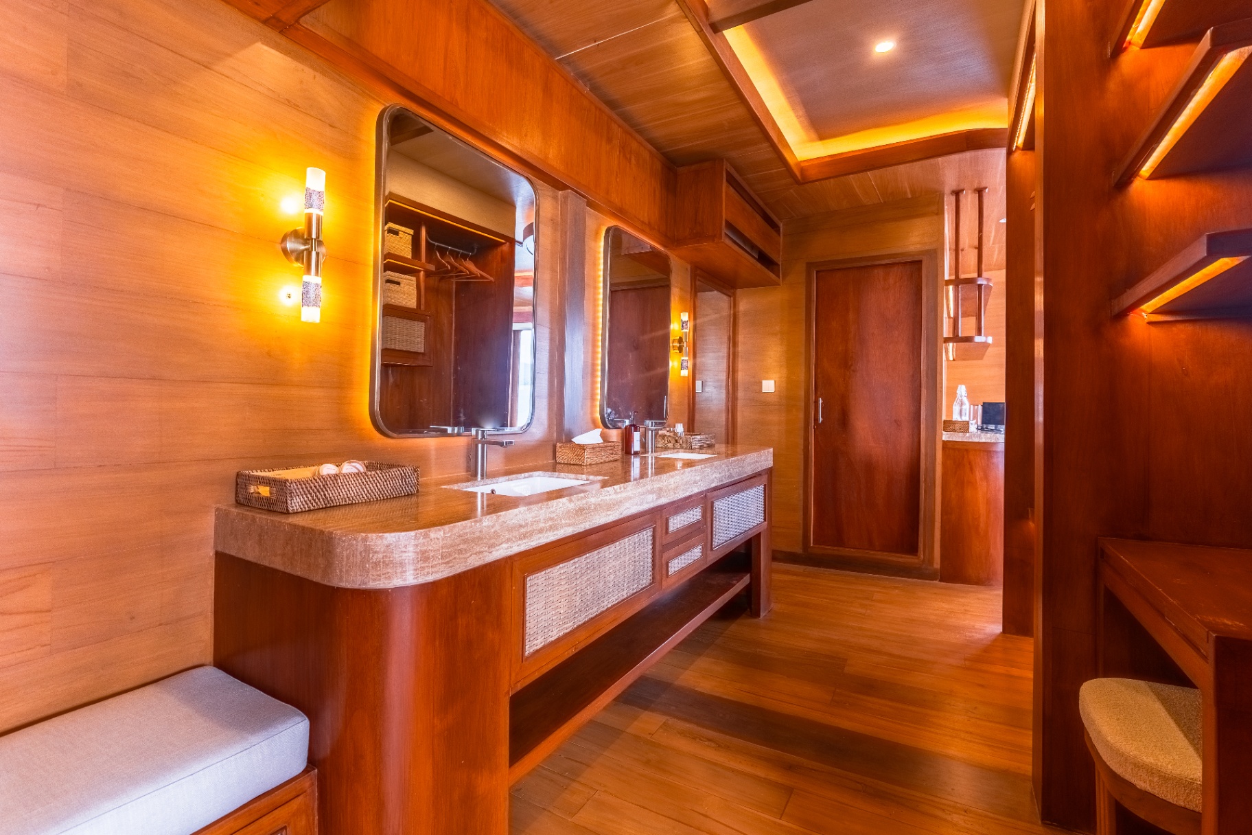 Master ensuite on Sanctuary with twin travertine basins, backlit mirrors and warm teak walls