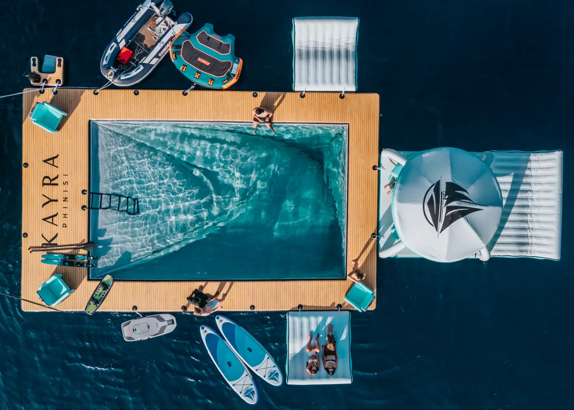 Top-down view of Kayra's floating pool platform with SUPs, floats and tenders