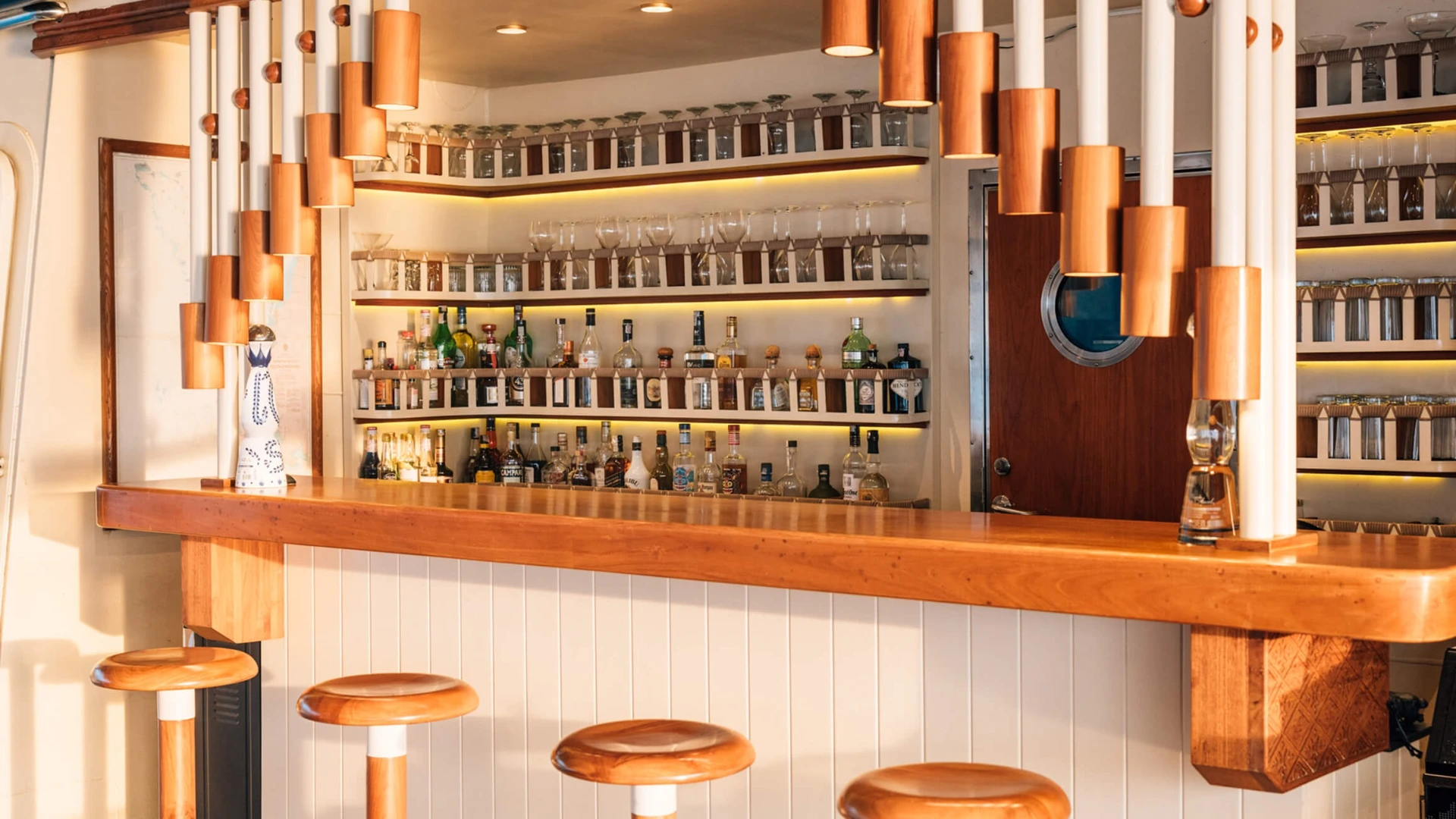 Fully stocked interior bar on Kudanil Explorer with timber counter and stools