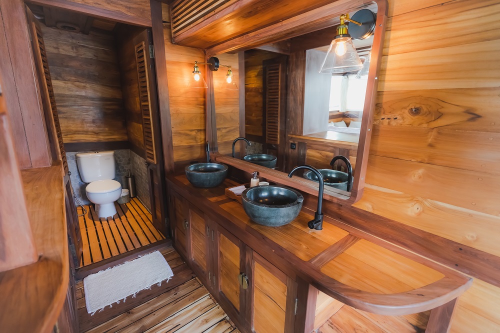 Master ensuite vanity on Senja with stone basins, mirror and glass sconces beside the WC