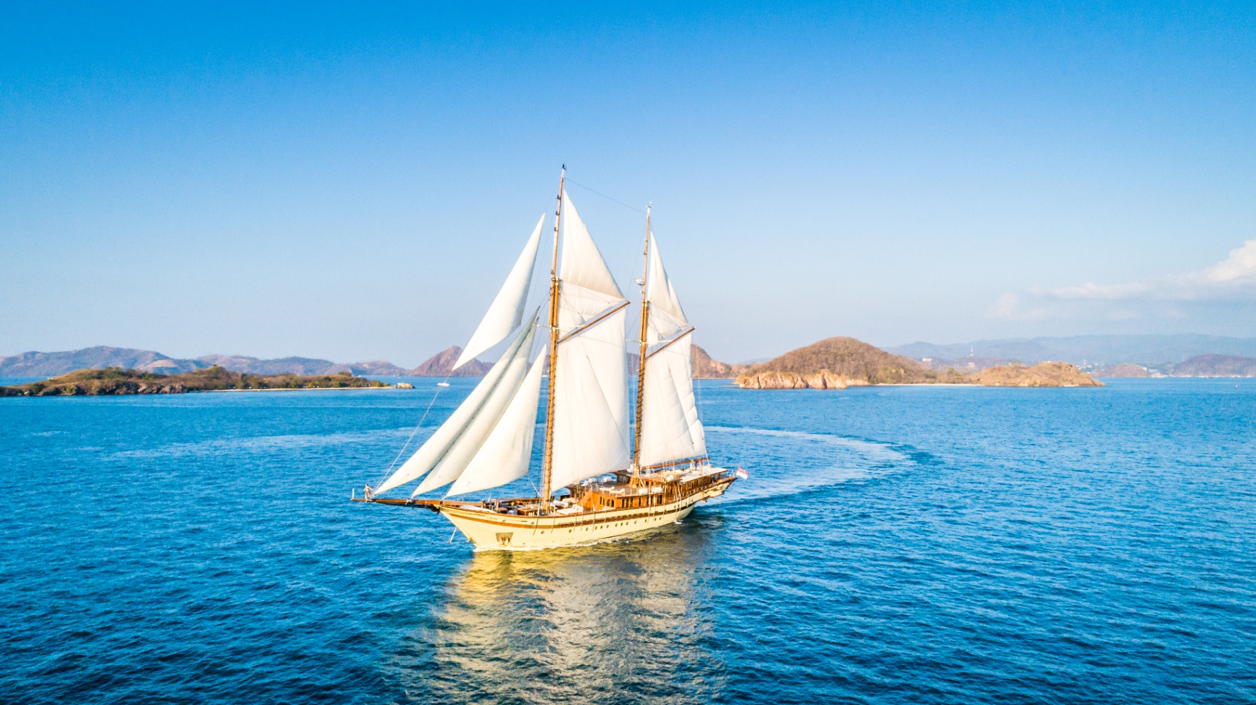 Lamima sailing off Labuan Bajo with the Flores islands behind her