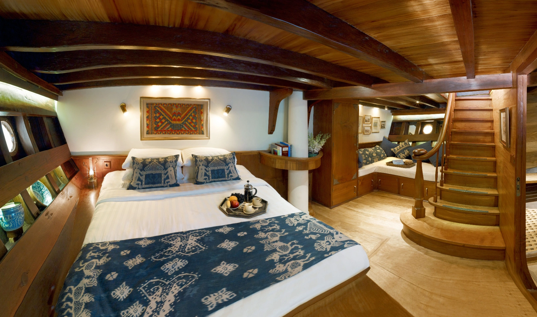 Master suite on Si Datu Bua with king bed, curved timber beams, ikat throw and staircase to private lounge