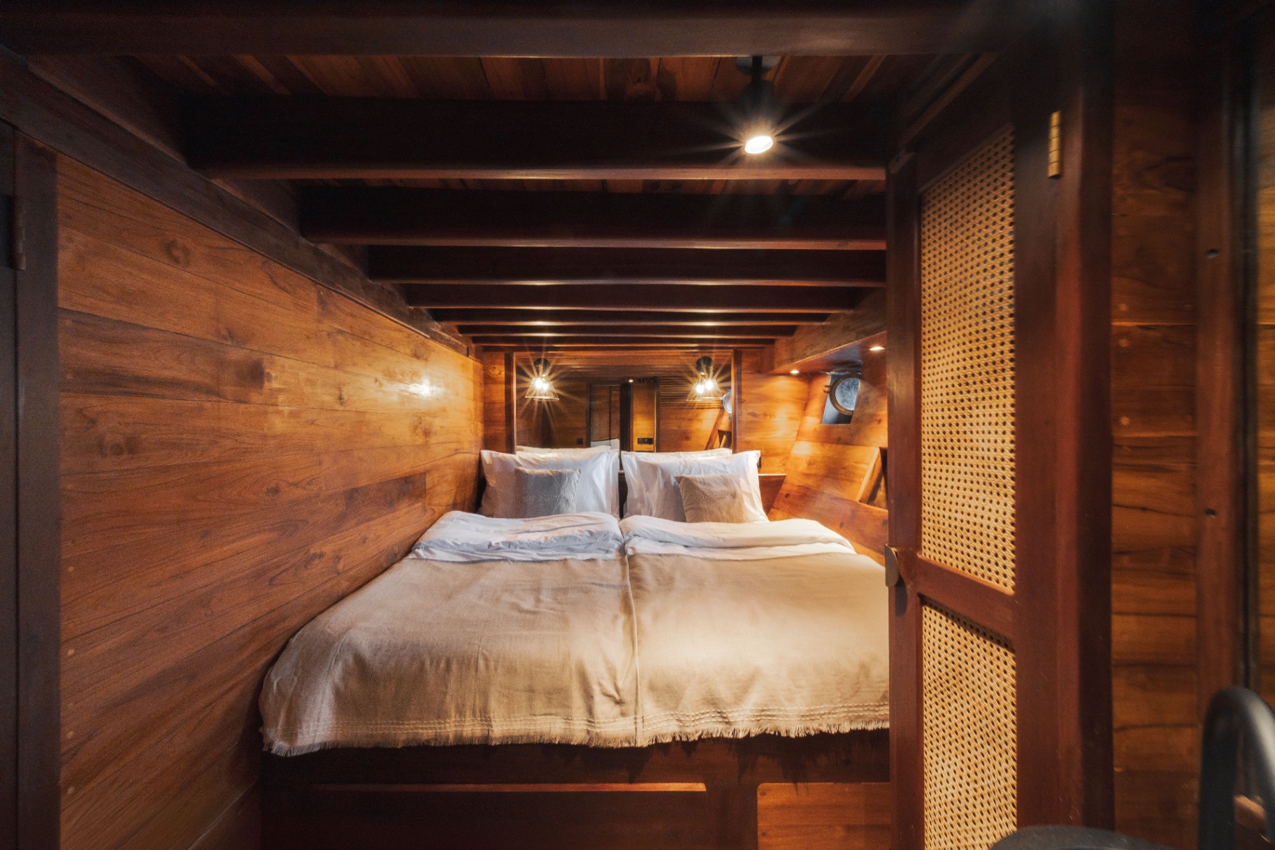 Deluxe cabin on Nataraja with king bed, teak panelling and a cane door