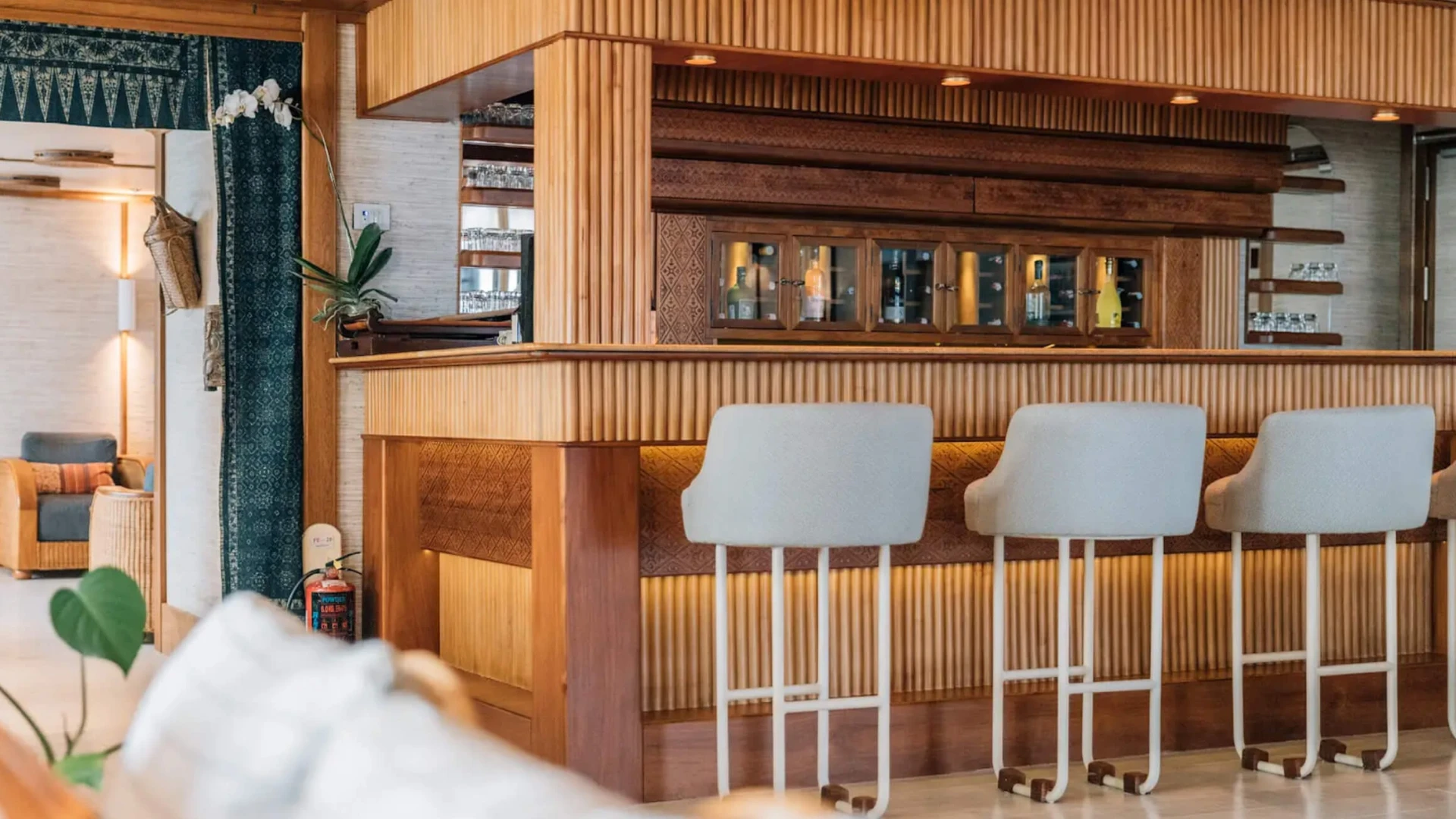 Interior bar on Kudanil Explorer with fluted timber, woven textiles and upholstered stools