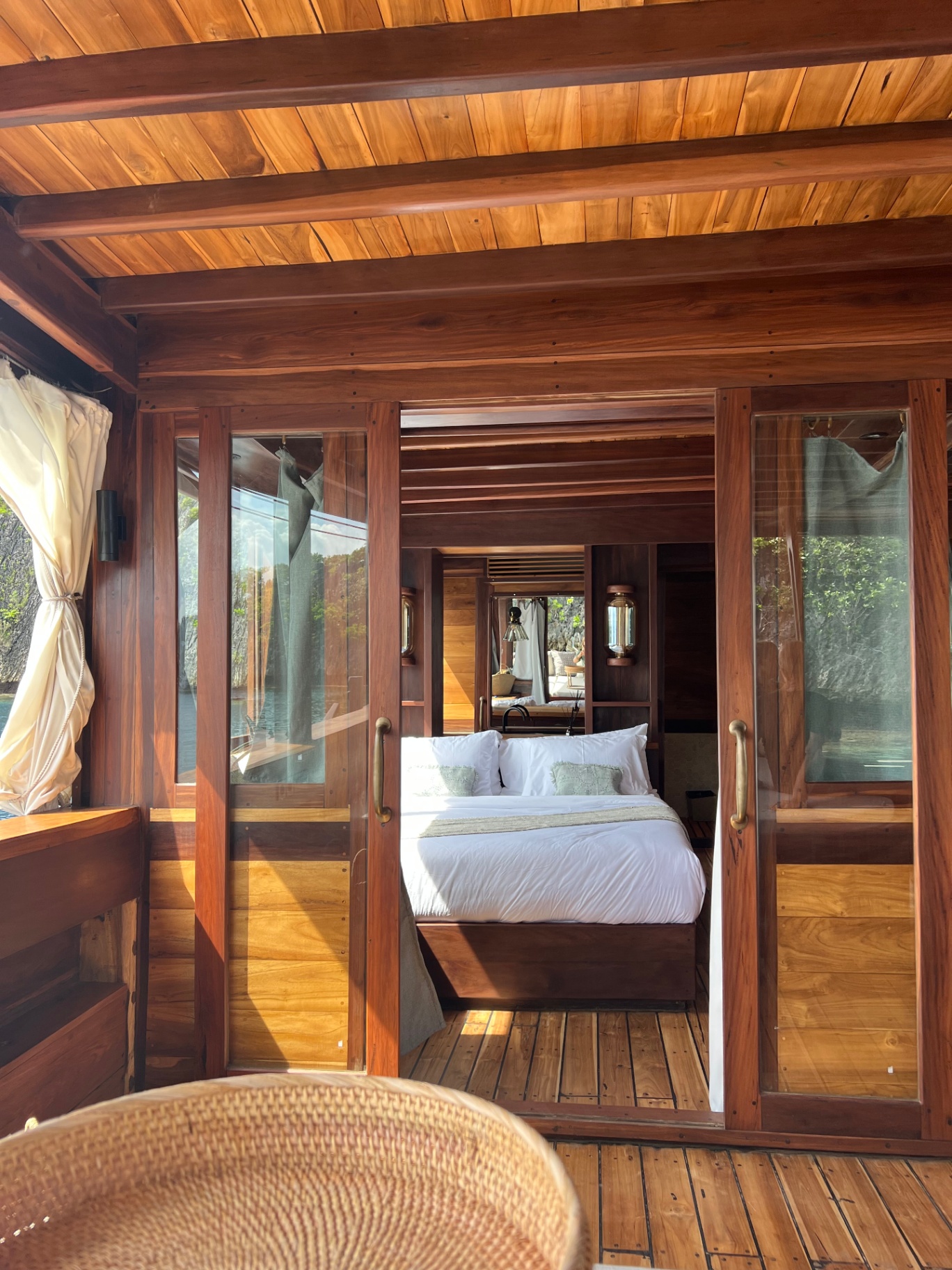 Sliding glass doors opening into Dewata's master cabin with king bed