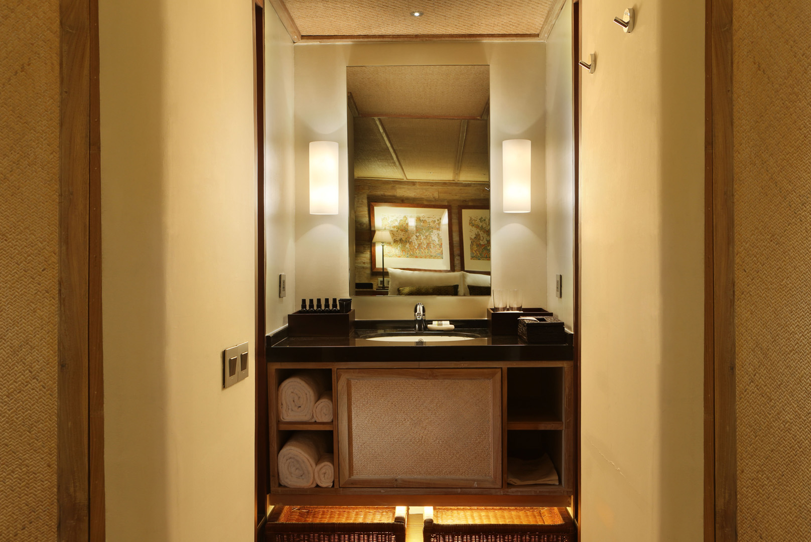 Guest suite vanity on Alila Purnama with granite counter, backlit mirror and woven ceiling