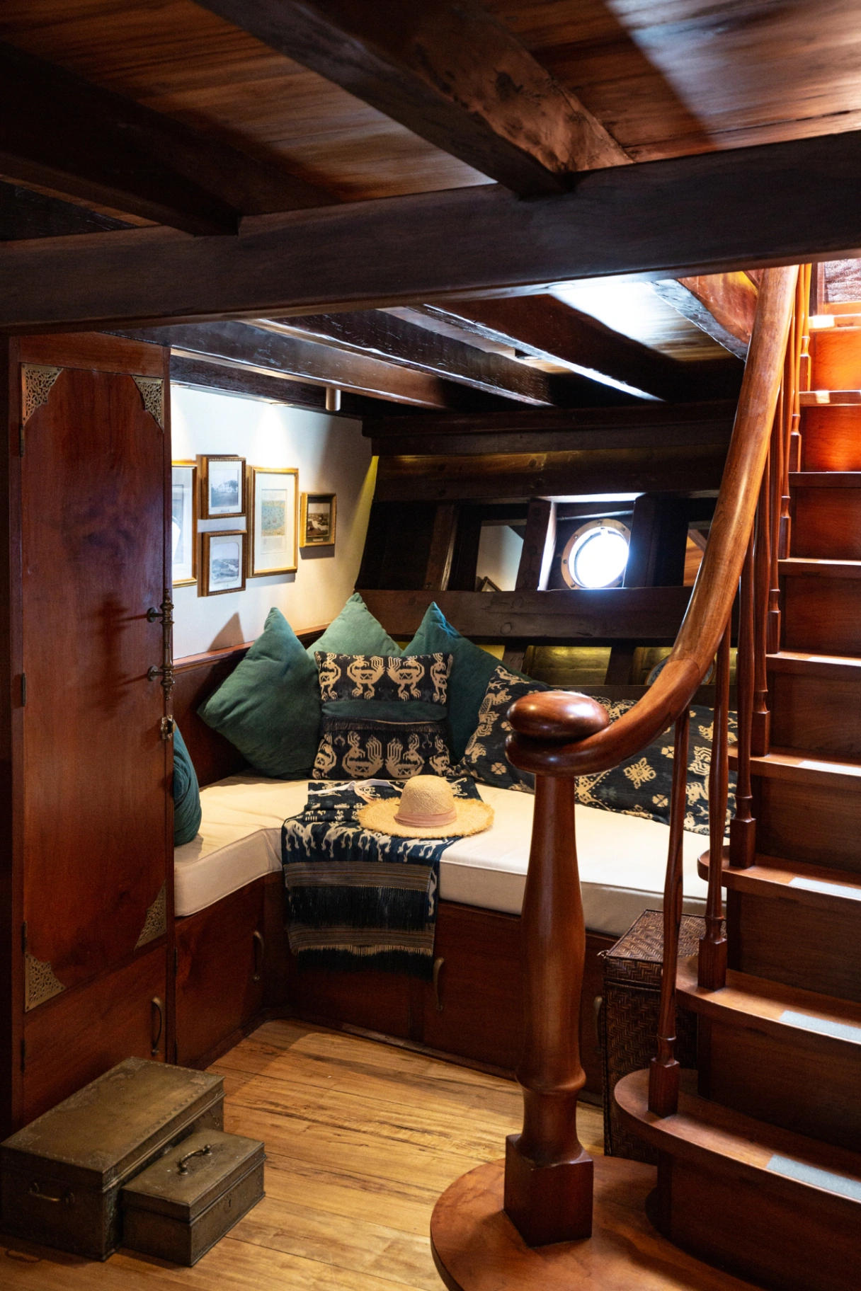Reading nook on Si Datu Bua with ikat cushions, porthole and curved timber staircase