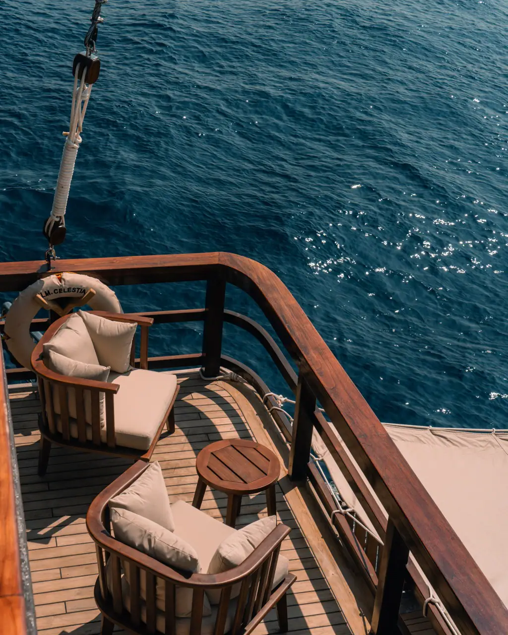 Corner armchairs on Celestia's aft deck overlooking deep blue sea