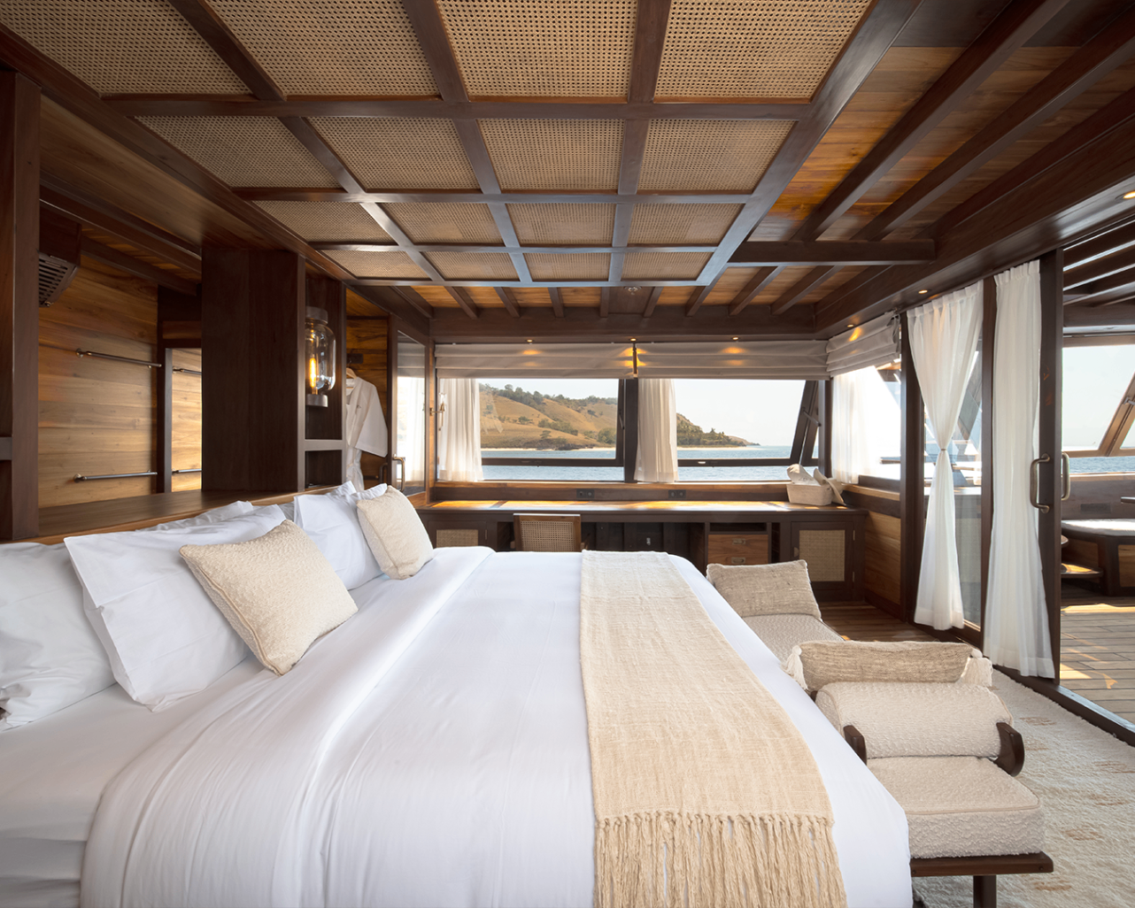 Sanya master suite with king bed, panoramic windows and view of Komodo hills