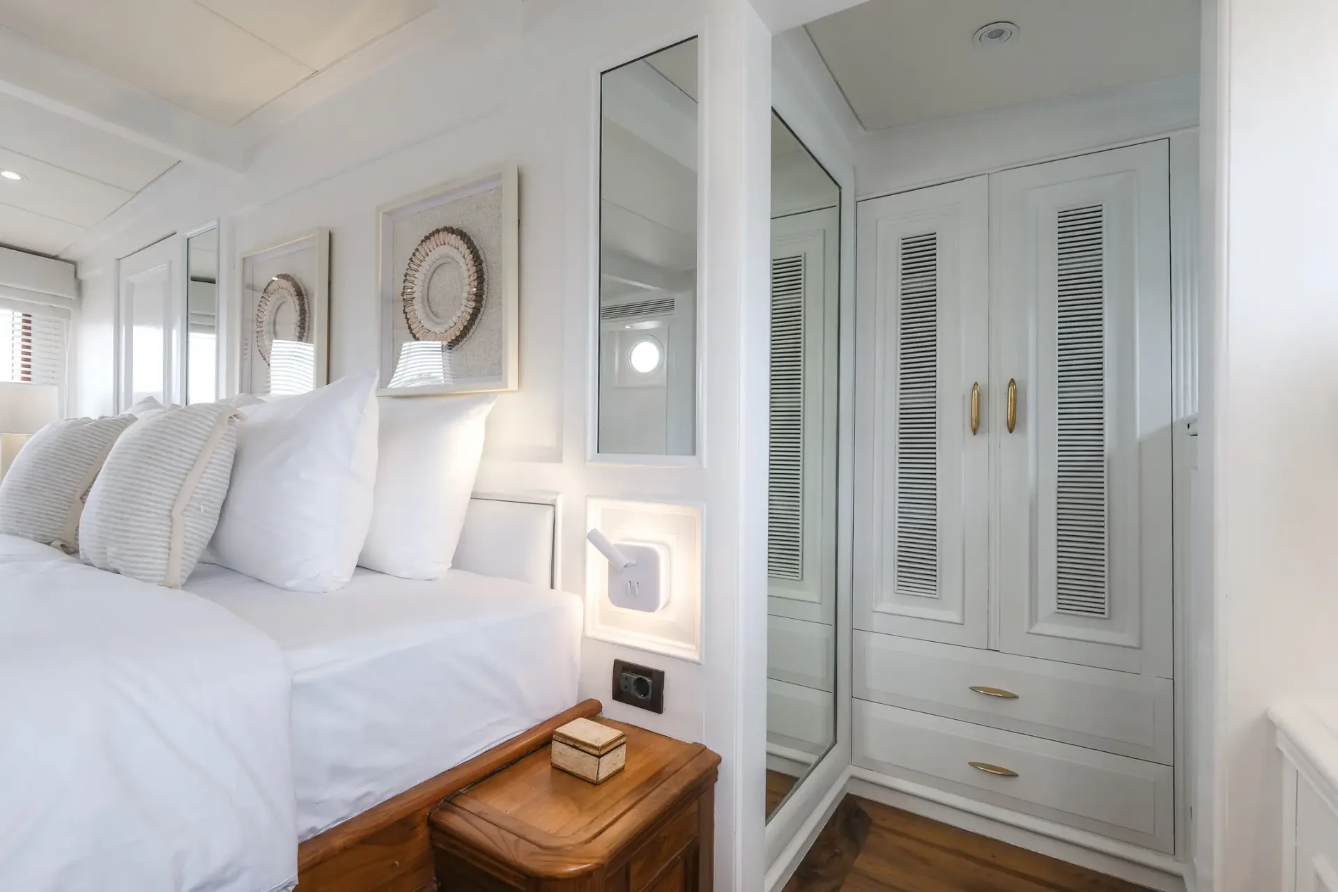 Mutiara Laut cabin detail with mirrored wardrobe and framed art above the bed