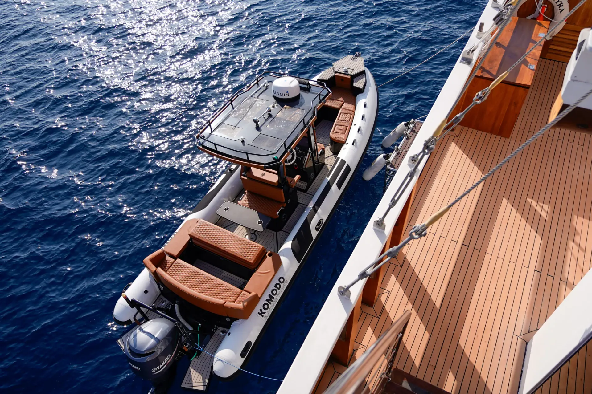 Kayra's Komodo-class RIB tender tied alongside the teak side deck