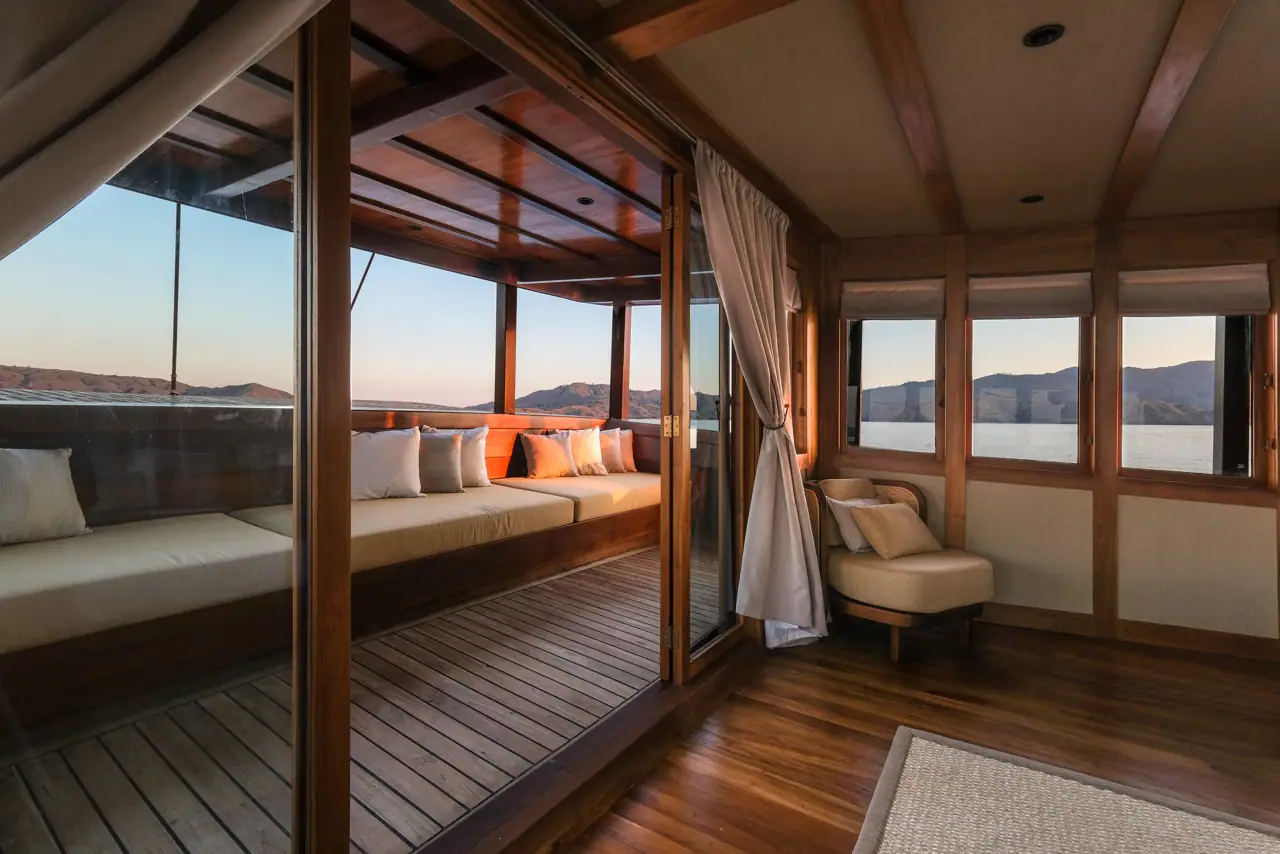 Celestia master stateroom private terrace with daybeds at golden hour, Raja Ampat