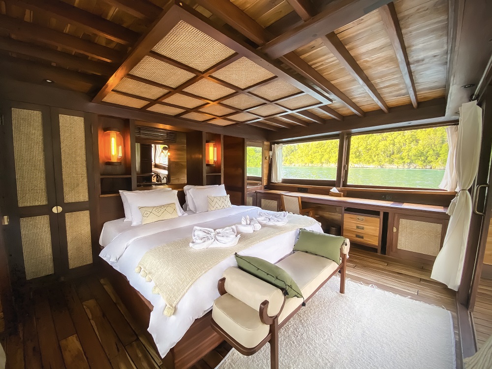 Master cabin on Senja seen from the side with king bed and panoramic windows to Raja Ampat