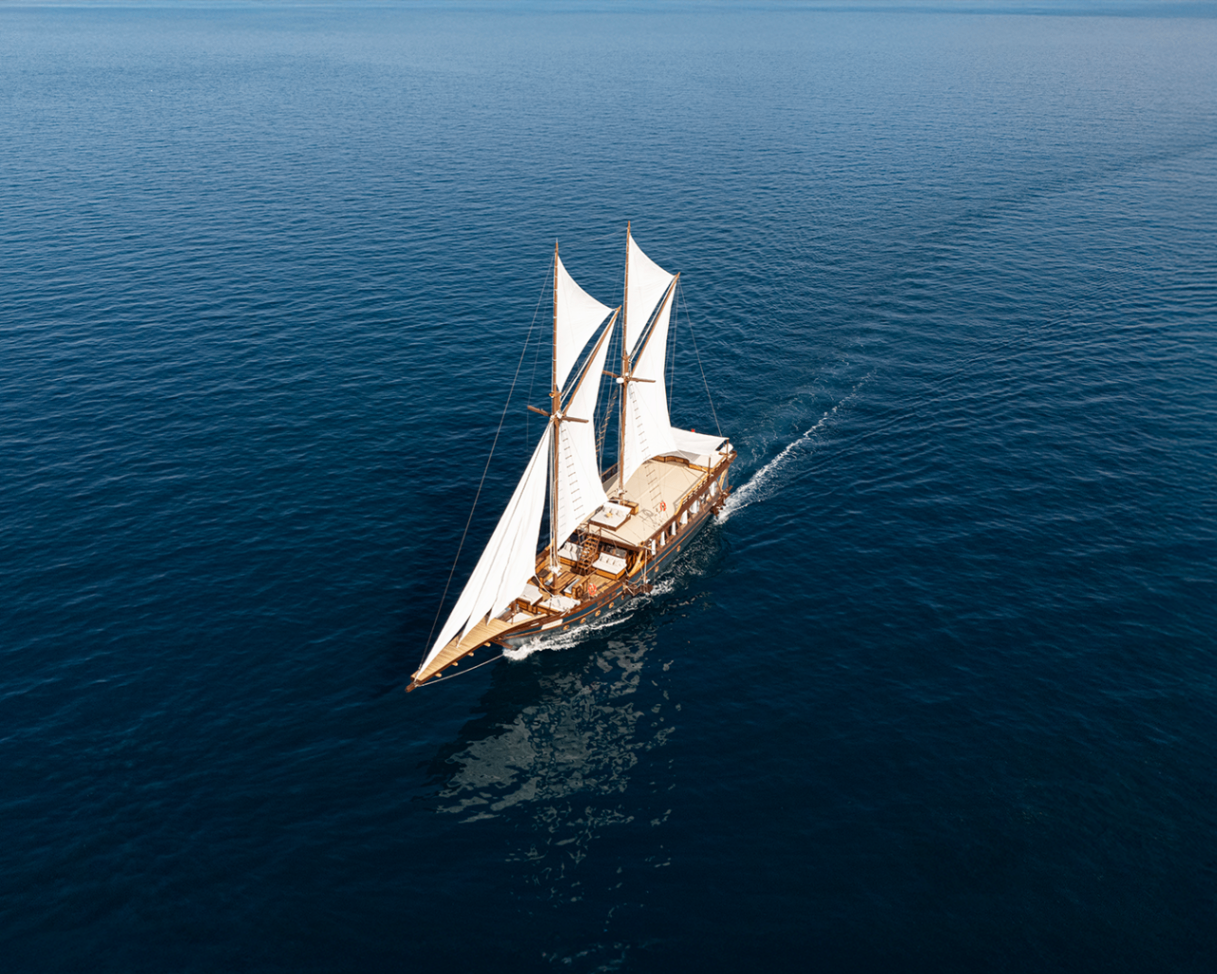 Aerial bow-quarter view of Sanya sailing across dark blue sea