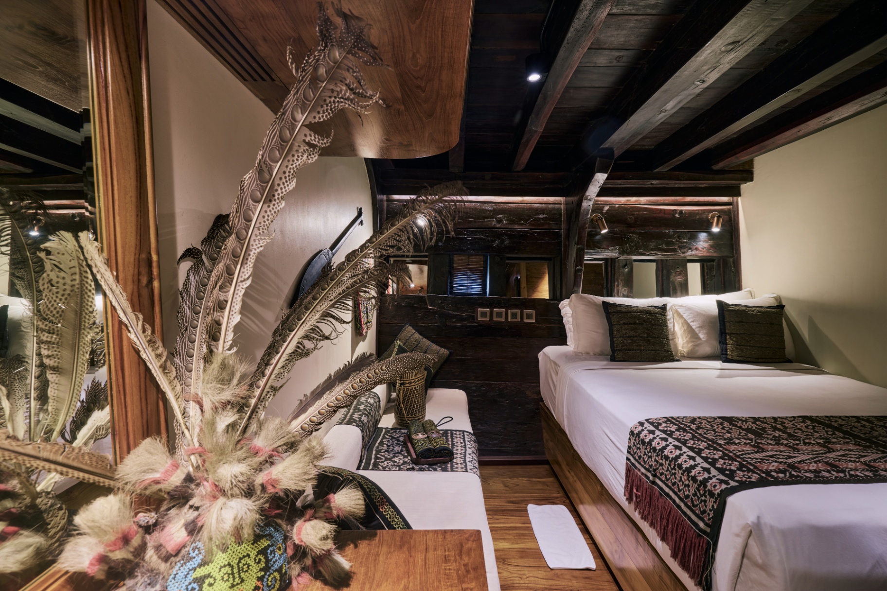 Asmat-themed suite on Silolona with tribal feathers, ikat runners and antique ironwood ribs