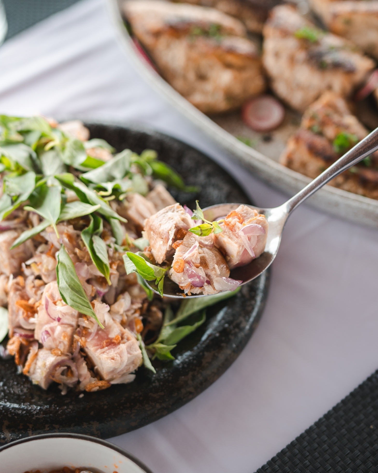 Indonesian tuna salad with shallots, crispy garlic and Thai basil in a stone bowl aboard Mischief