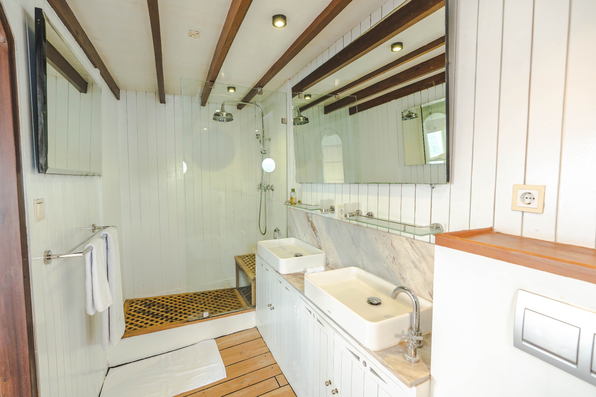 Komodo suite ensuite bathroom on Mischief with twin vessel sinks, marble counter and glass rain shower