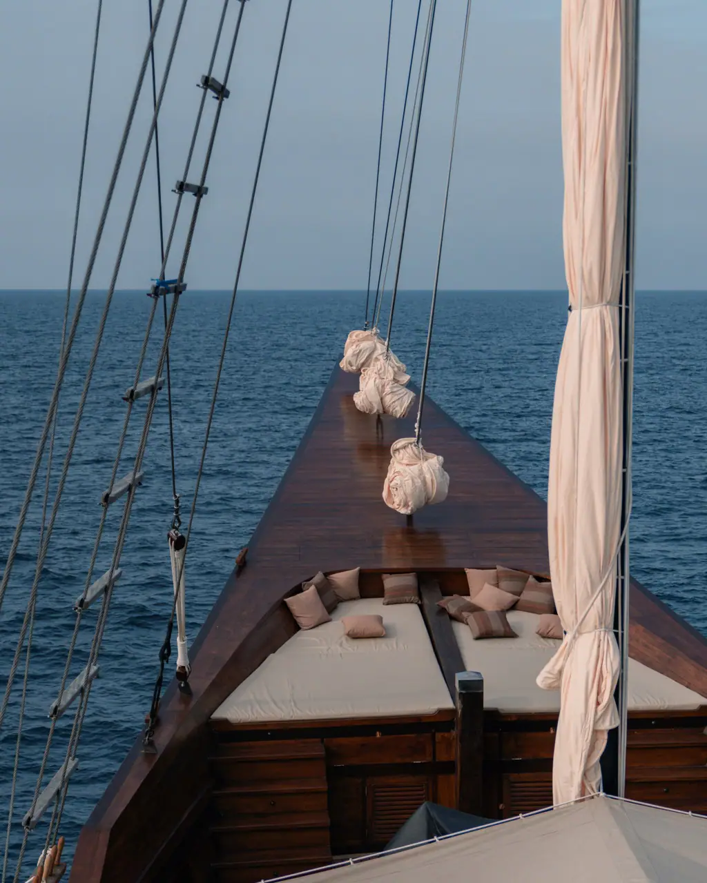 Celestia bow with daybeds and cream sail-tie curtains, open sea view
