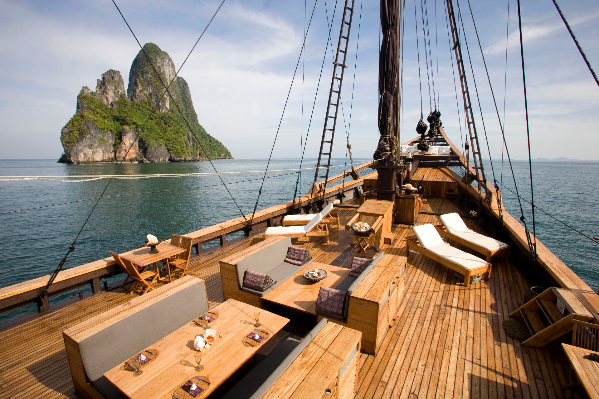 Silolona teak foredeck lounge and sun loungers with a limestone karst island beyond