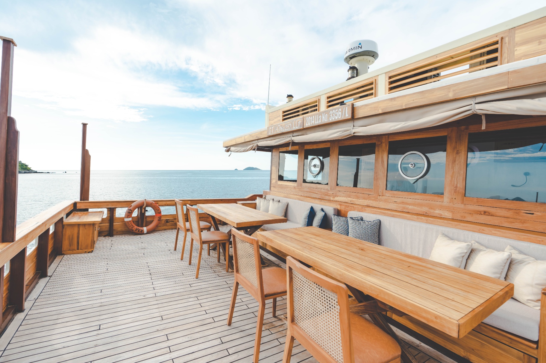 Mischief upper-deck social area with wraparound bench seating and open ocean horizon