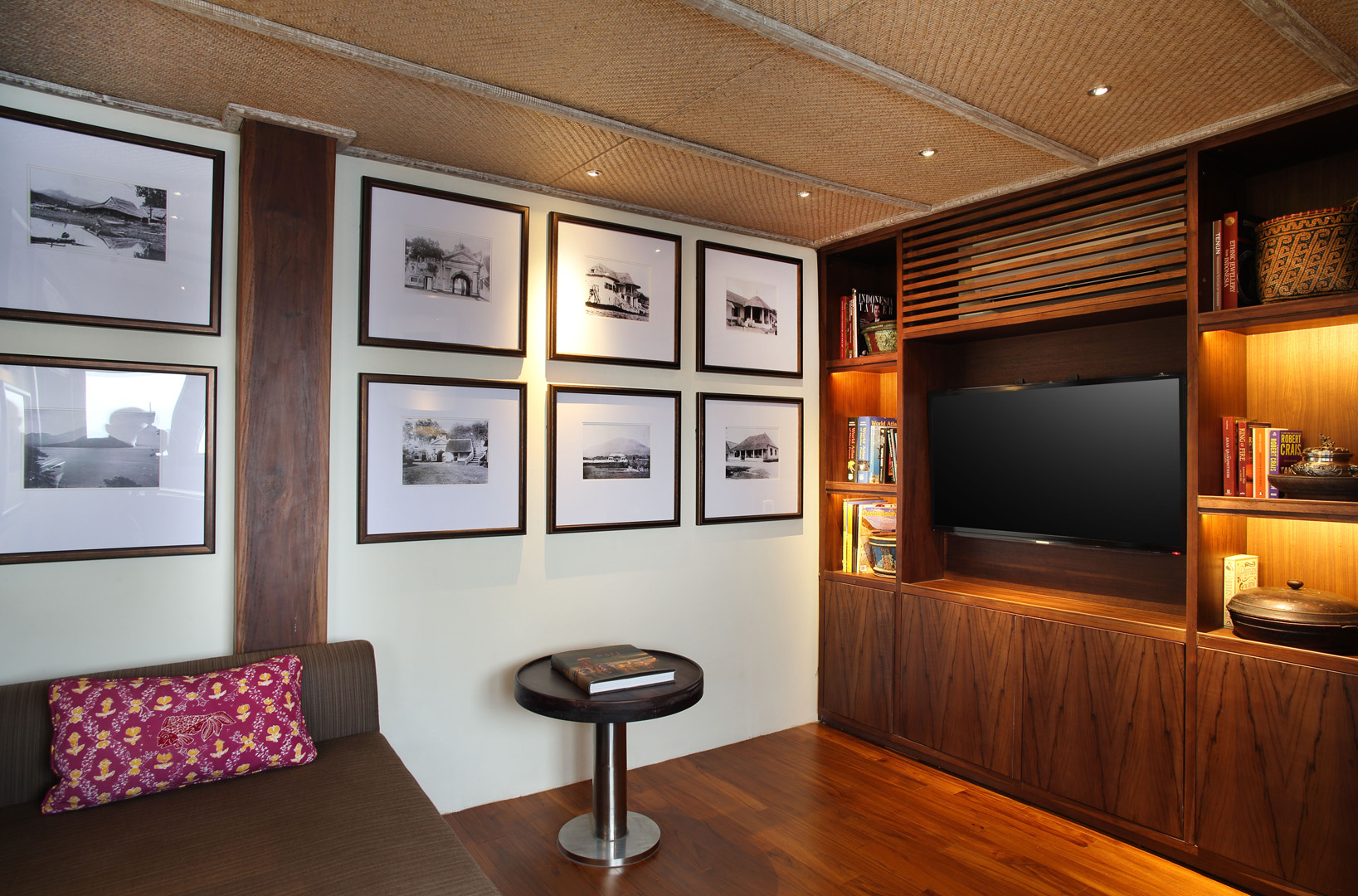 Library on Alila Purnama's nav deck with framed prints, books and entertainment console