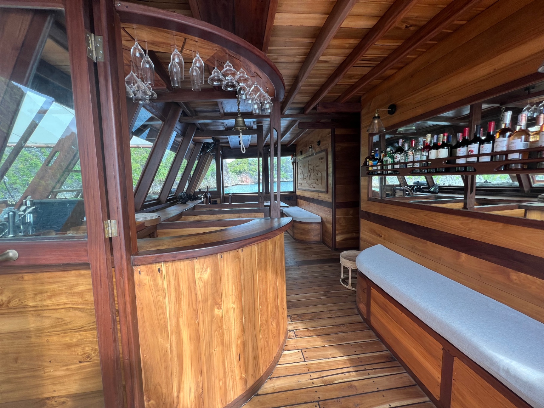 Dewata's interior bar with hanging glassware, wine selection and cushioned bench