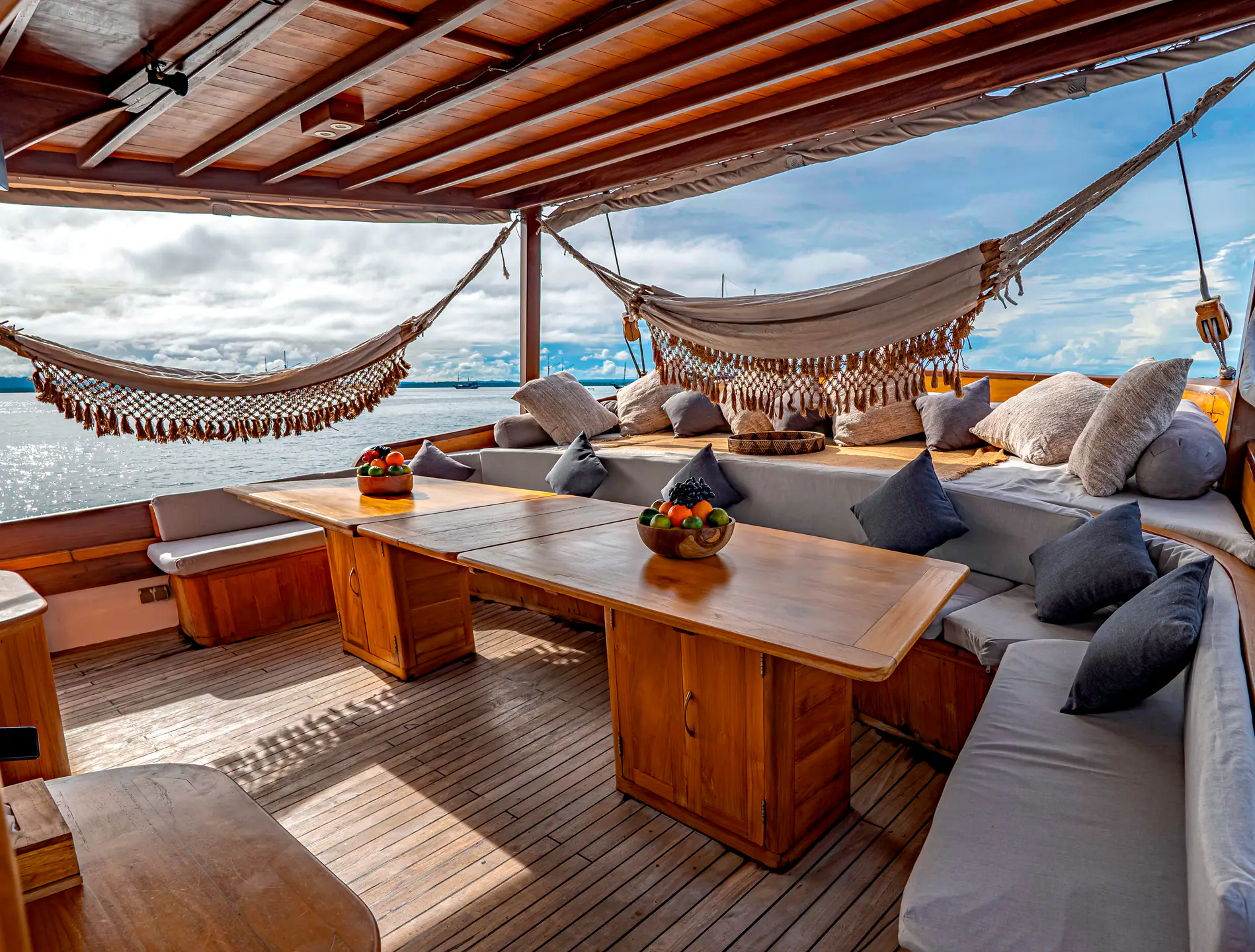 Anne Bonny aft deck with twin hammocks, sofas and dining table over the sea