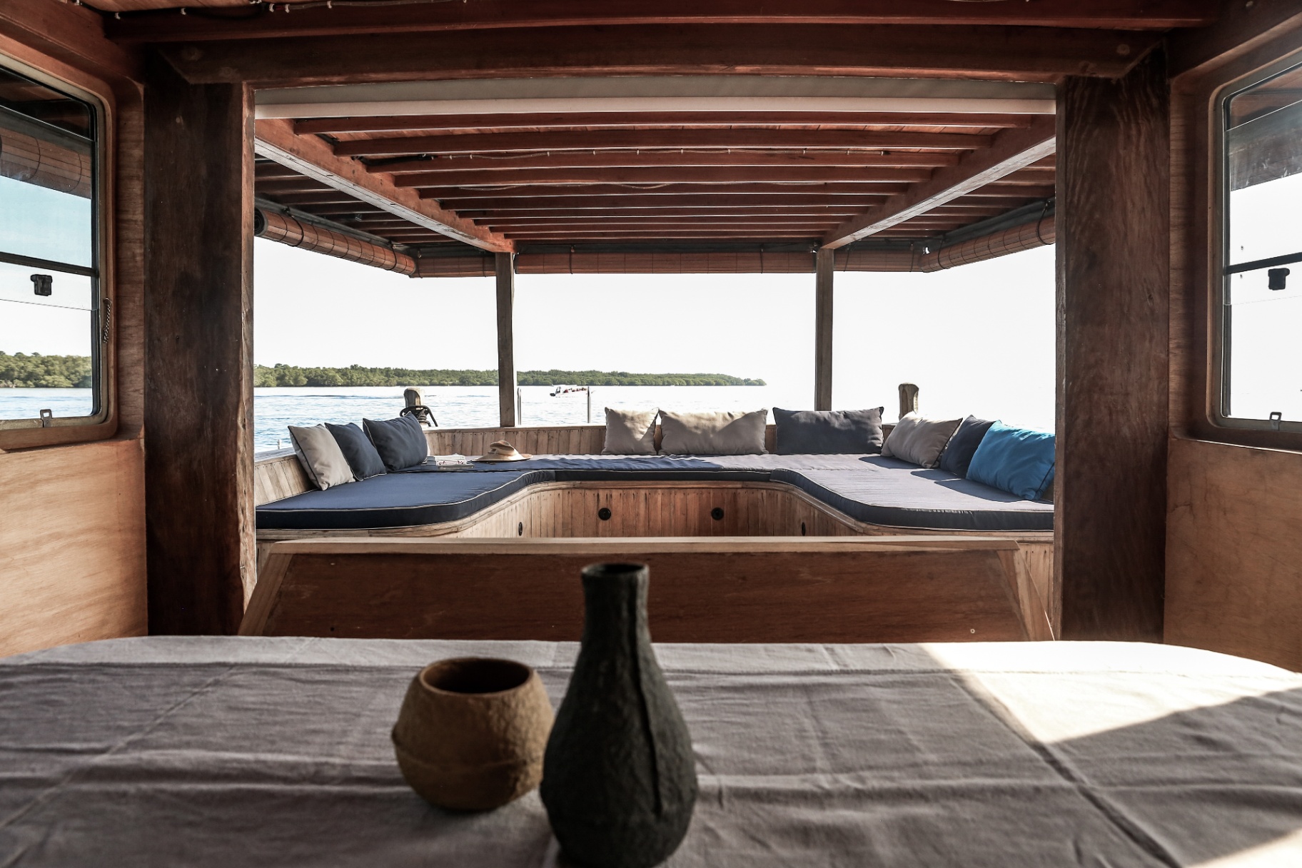 Splendour dining area looking out to the covered lounge, with linen table setting and ceramic vases