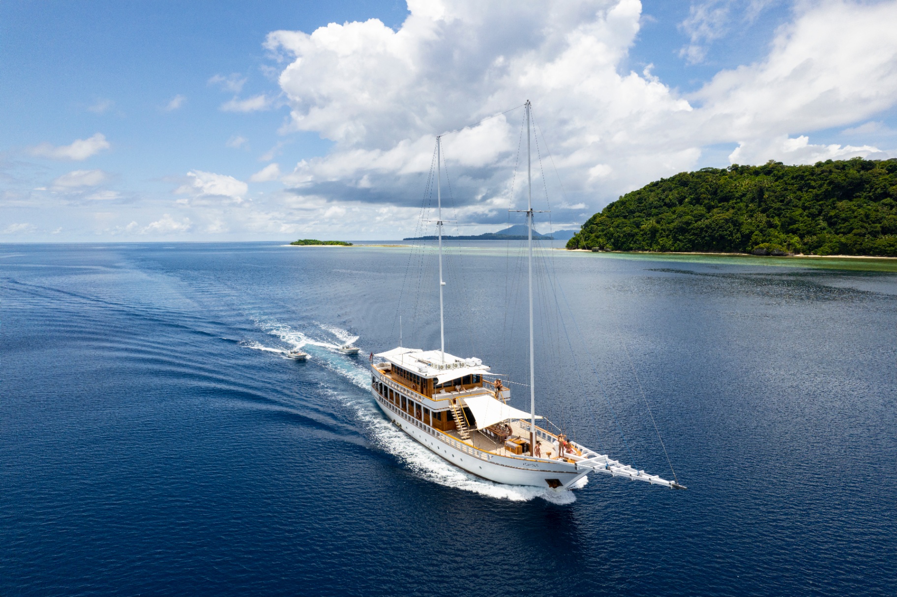 Aerial view of Fenides Liveaboard cruising with two dive tenders following in her wake