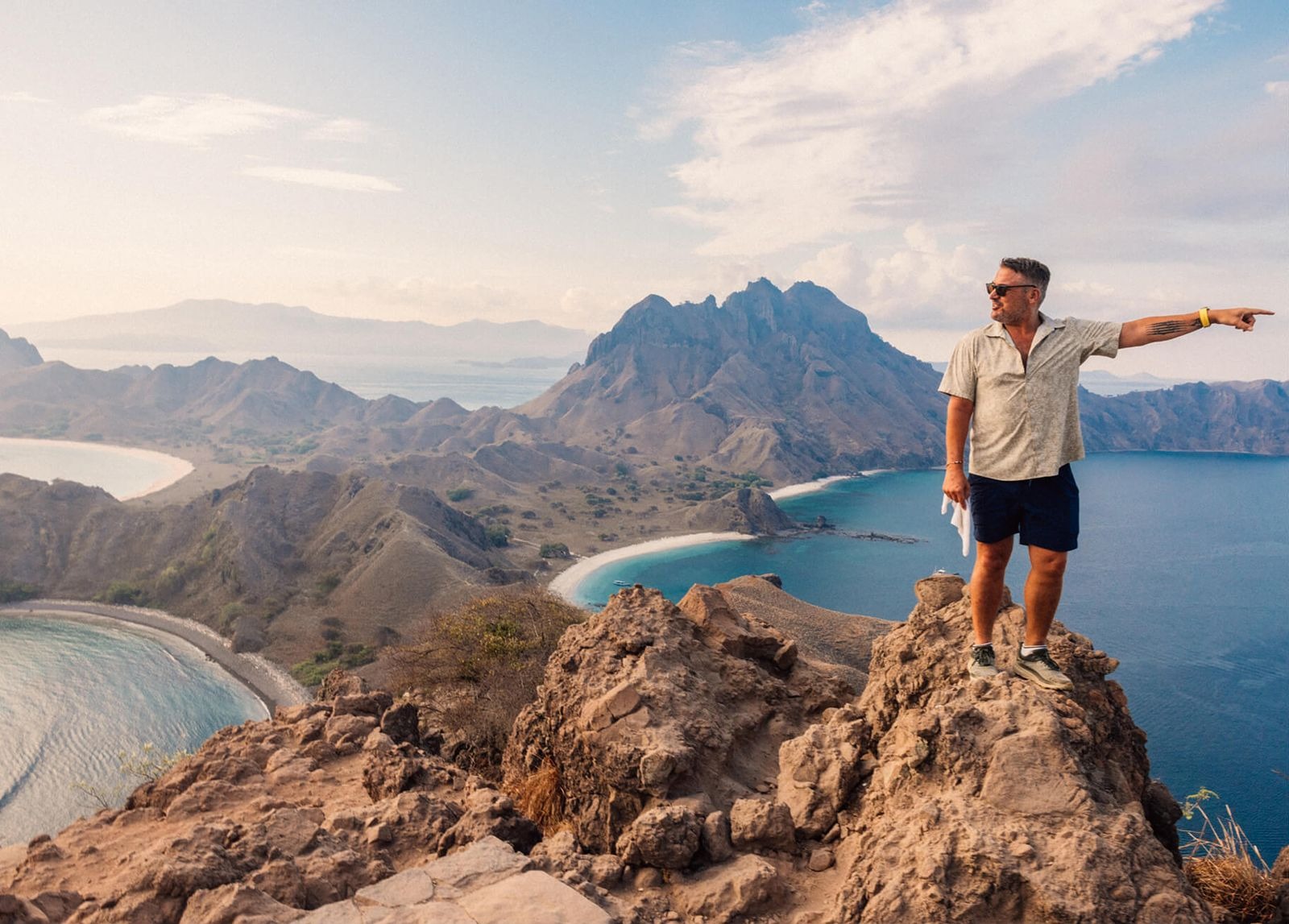 Guest at the summit of Padar Island pointing to the three bays below