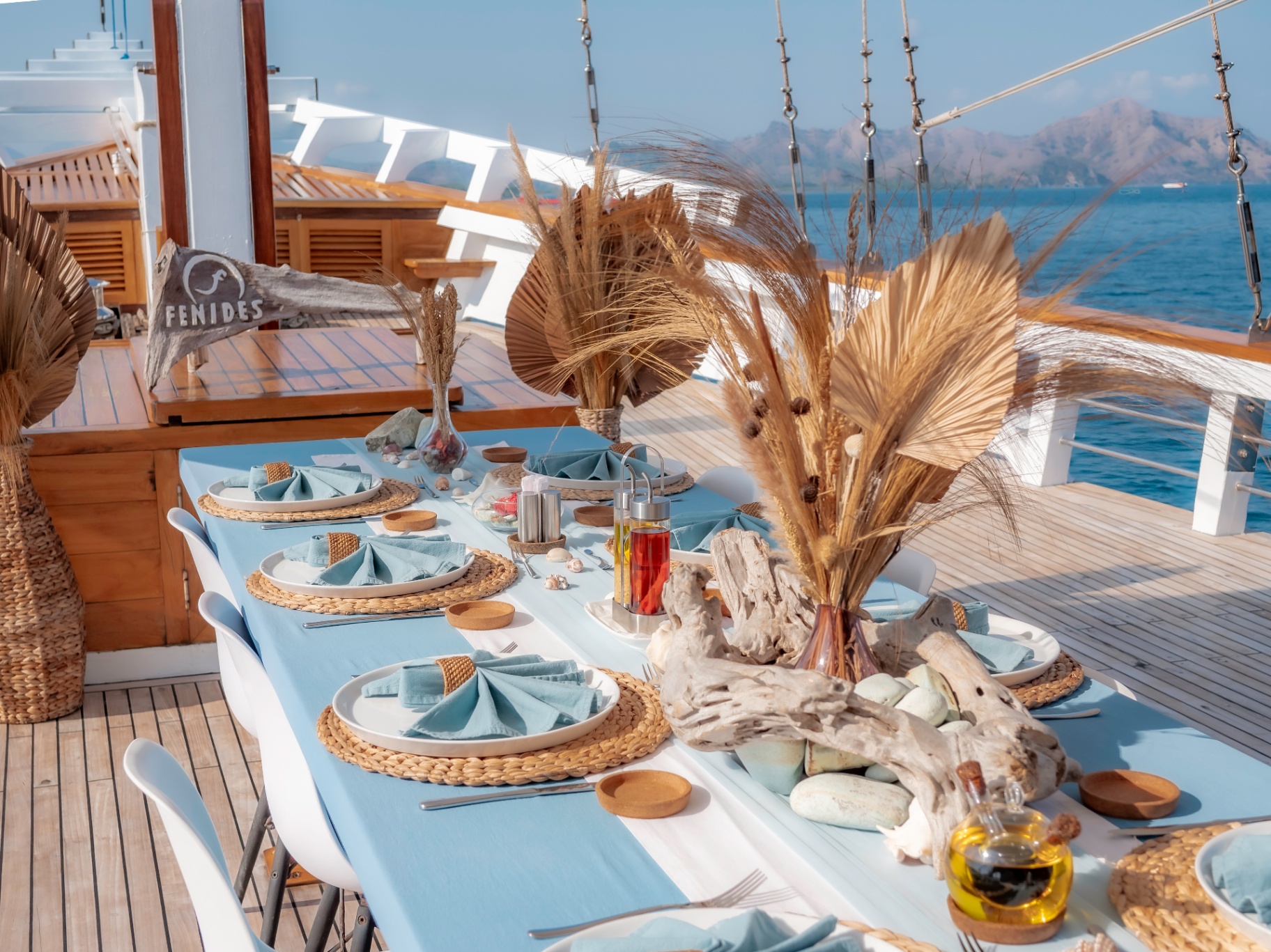Al-fresco dining table set on the Fenides deck overlooking Komodo