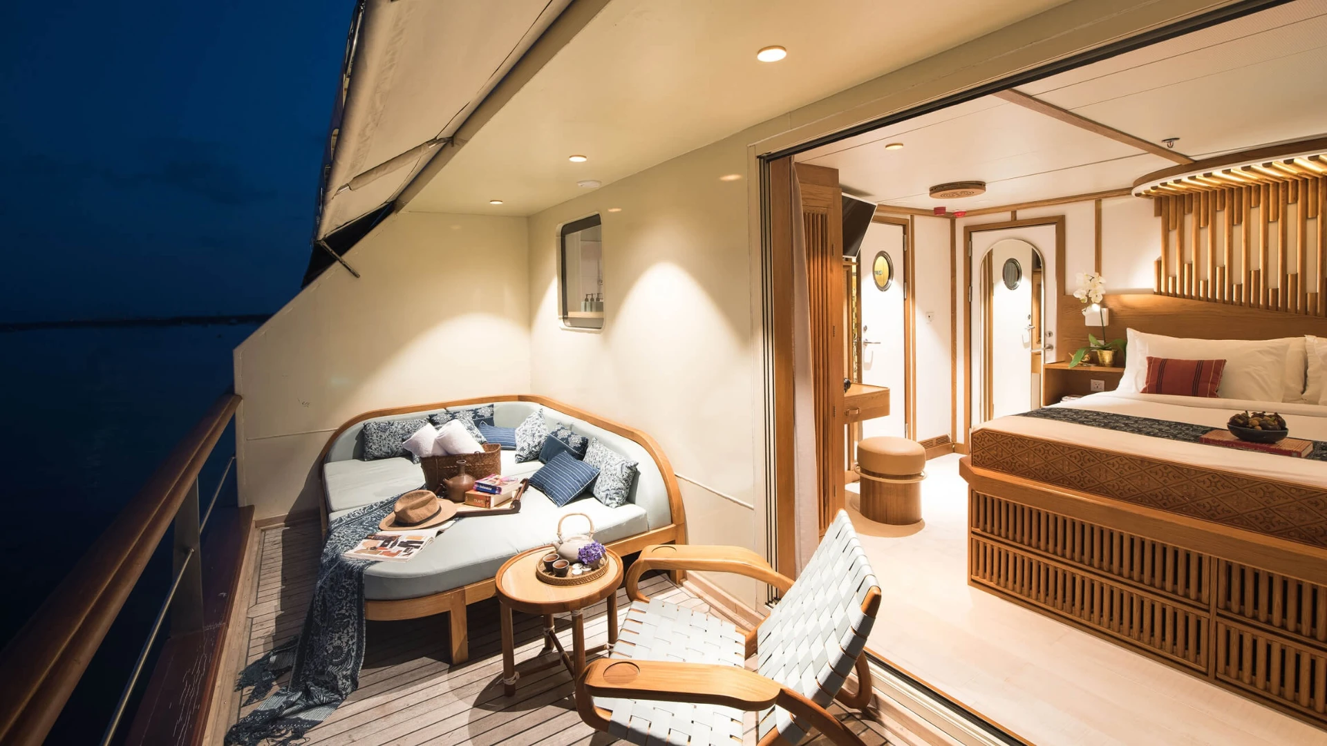 Private cabin balcony on Kudanil Explorer with day bed and lounge chair at night
